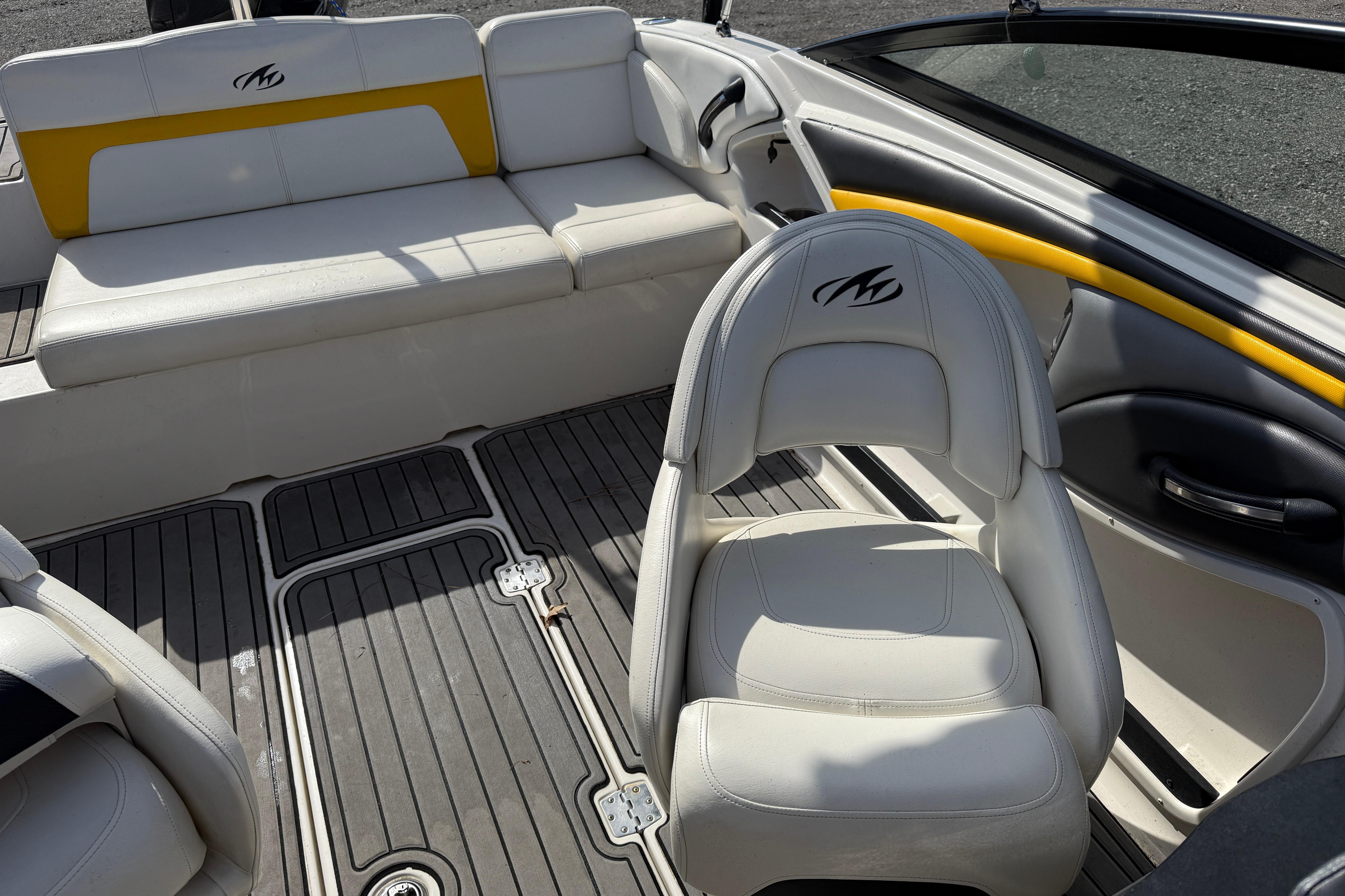 Interior of a 2014 Monterey 197 Blackfin boat with white seating and yellow accents.