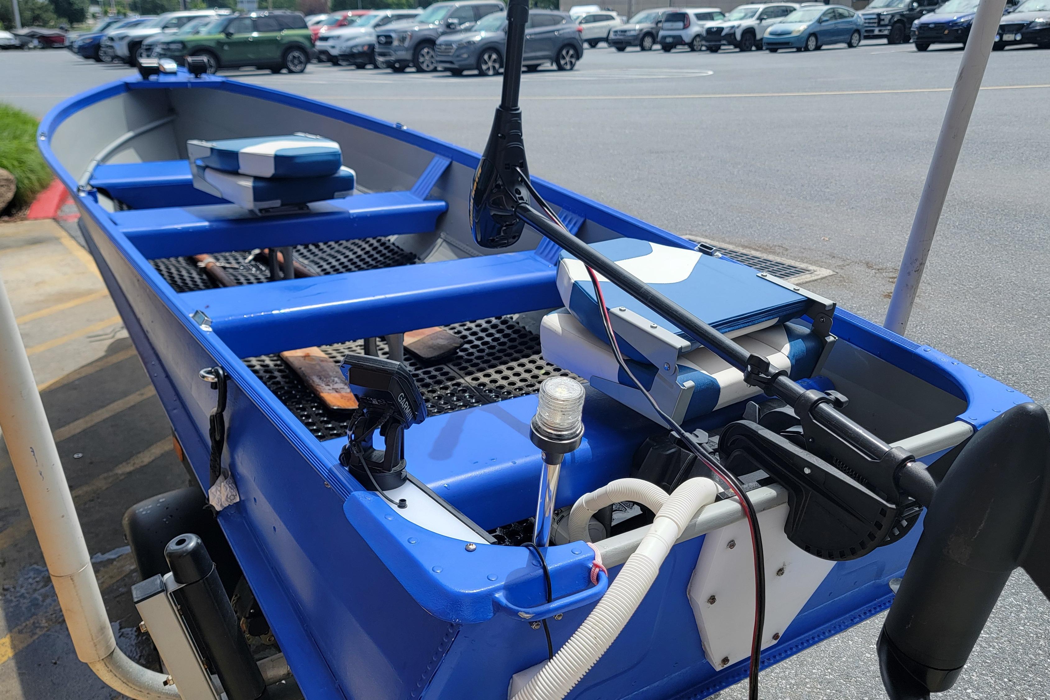 1966 Sea Nymph V-14 boat with blue interior and modern equipment in a parking lot.