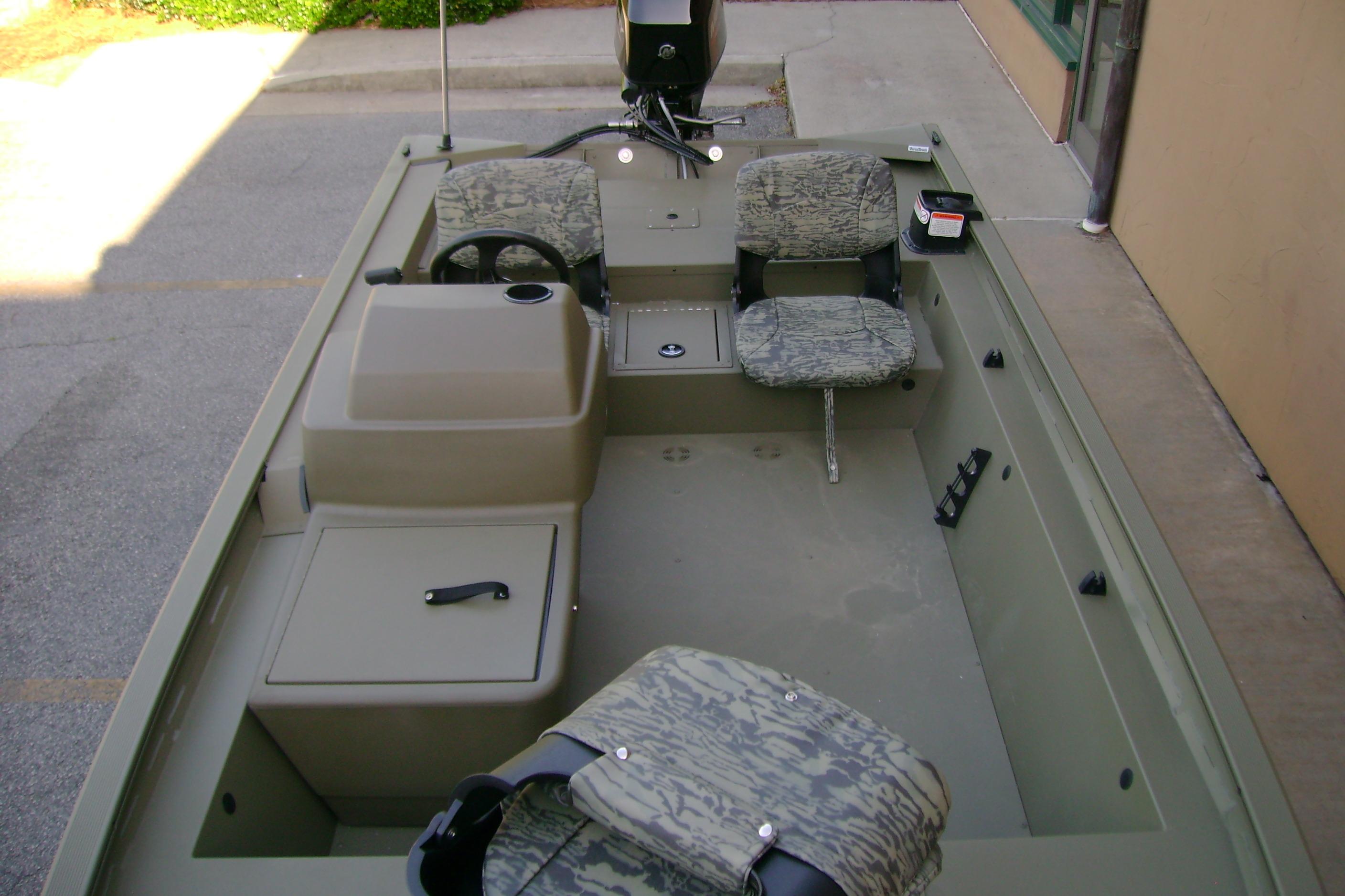 2026 Tracker Grizzly 1754 SC boat interior with camouflage seating and steering console.