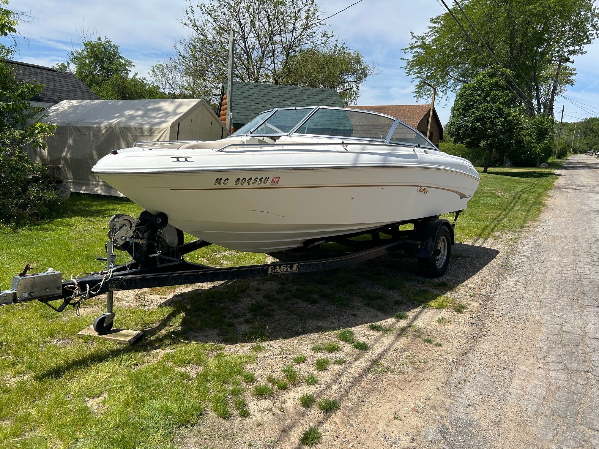 1998 Sea Ray 190 Bow Rider on trailer, parked on grass.
