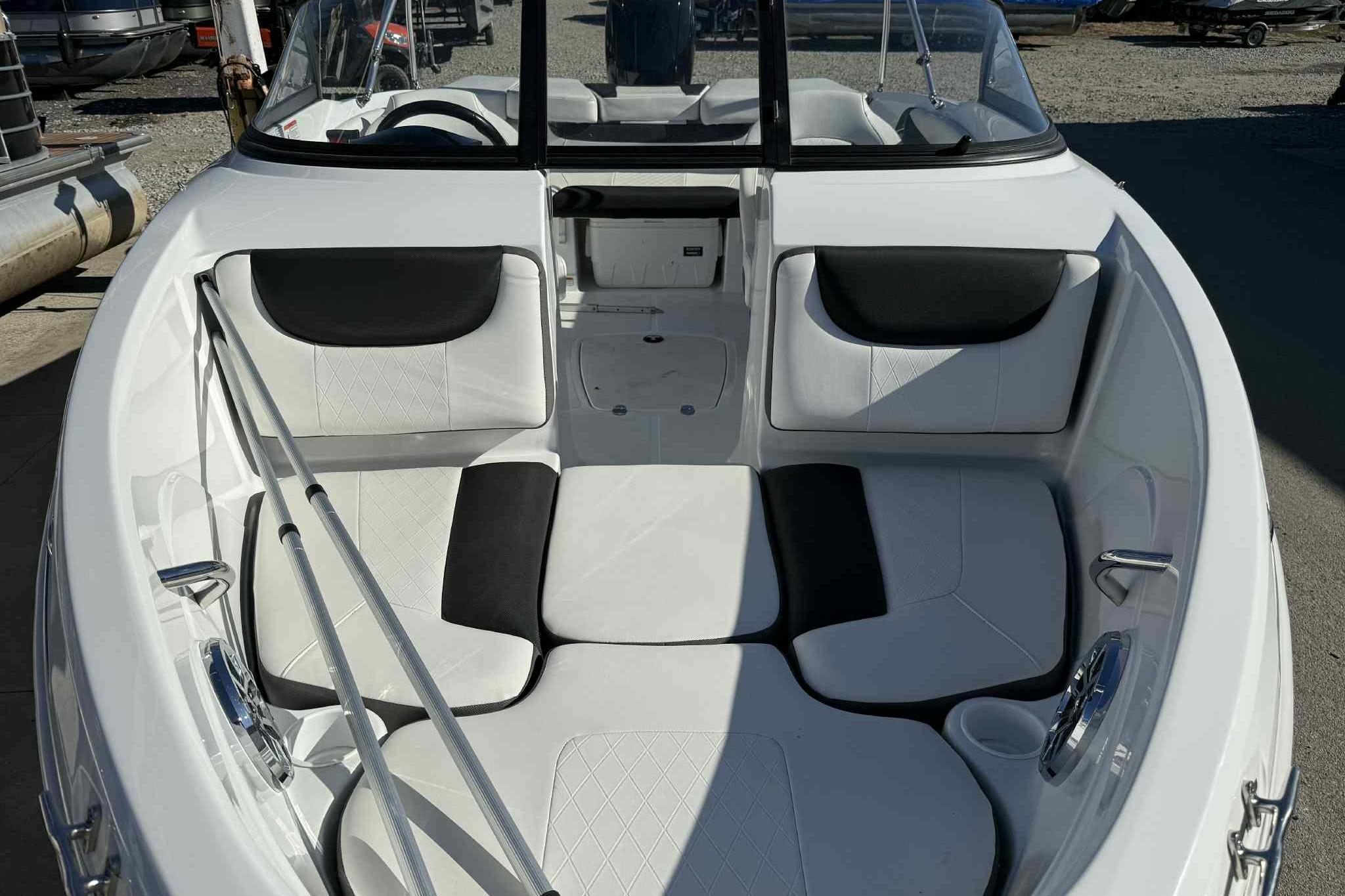 2021 Tahoe 550 TS boat interior with white and black seating, docked outdoors.