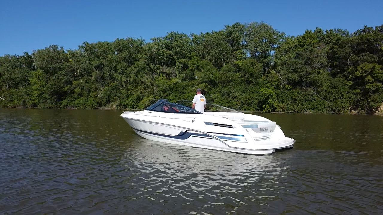 2019 Formula 240 boat on calm river with lush forest backdrop.