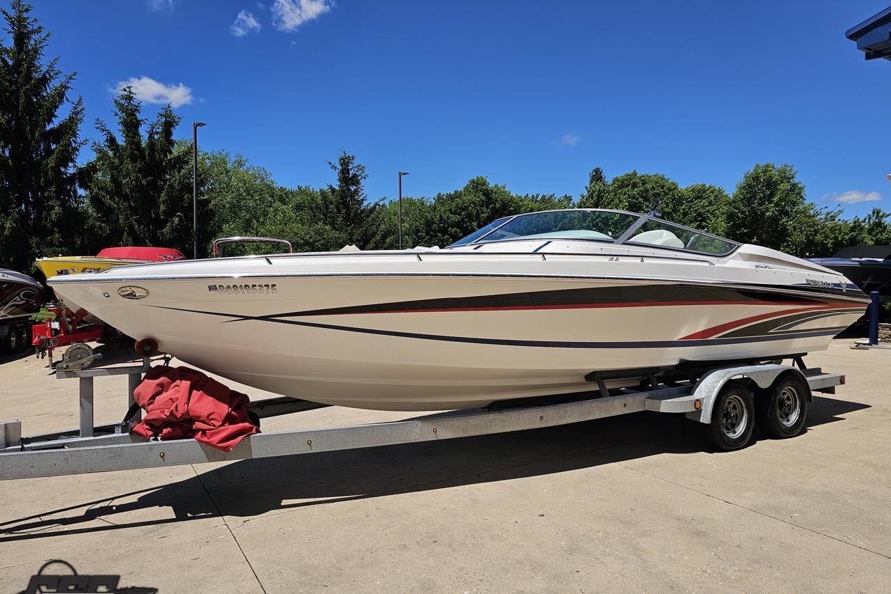 2005 Formula 271 FASTech boat on trailer, parked outdoors under clear blue sky.