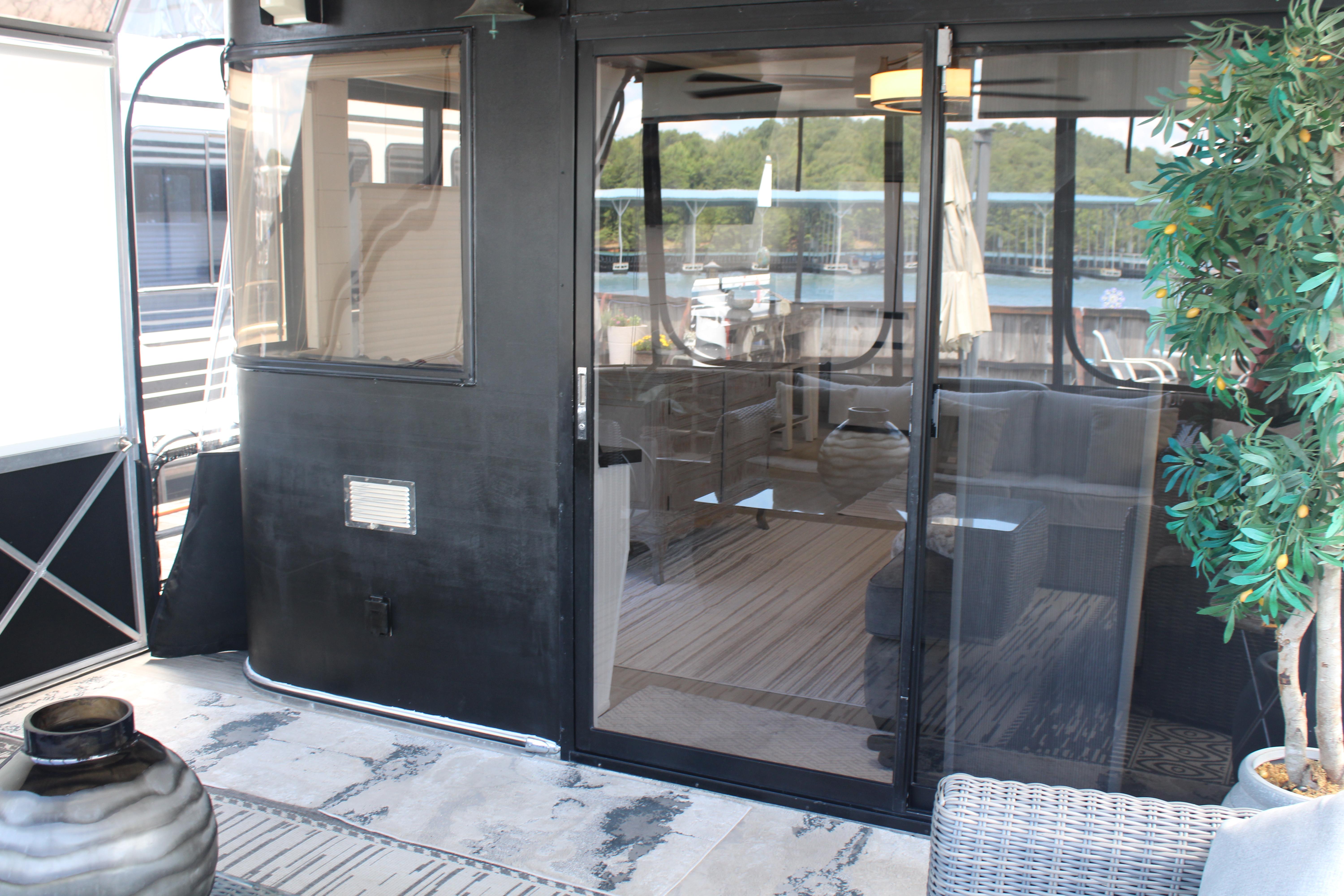 1992 Sumerset 66 houseboat with glass doors, outdoor seating, and lake view.