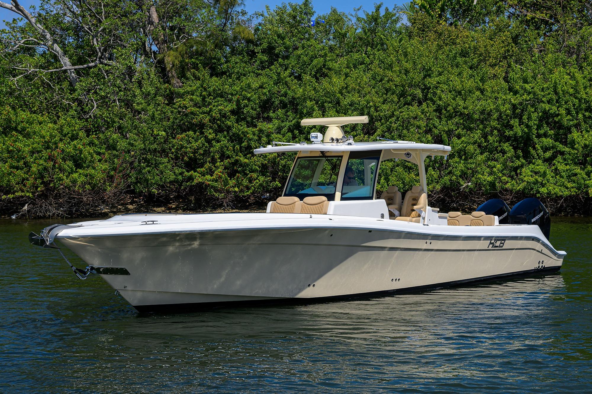 2024 HCB 39 Speciale boat on calm water, surrounded by lush greenery.
