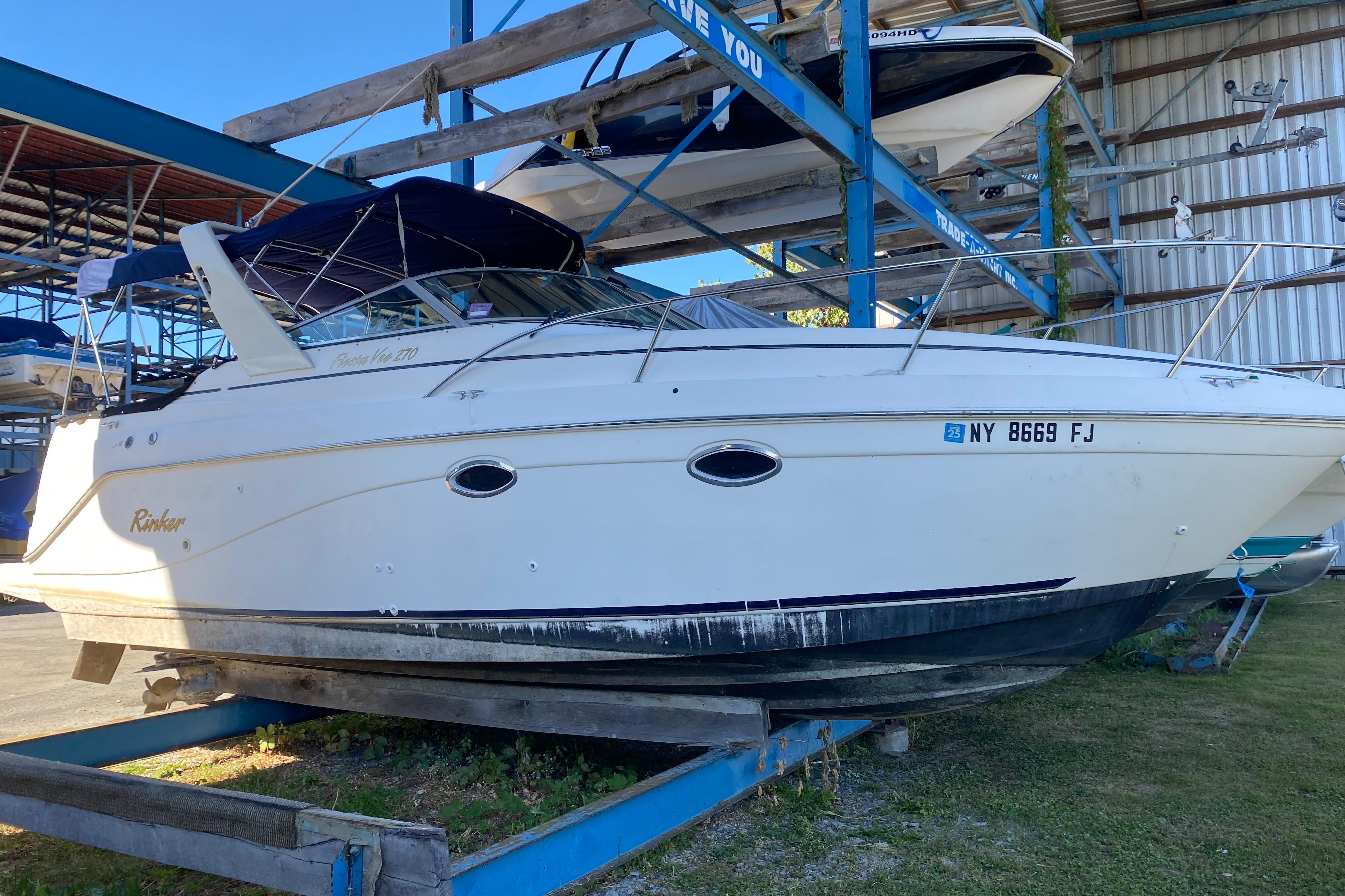 2003 Rinker Fiesta Vee 270 boat in dry dock, side view.
