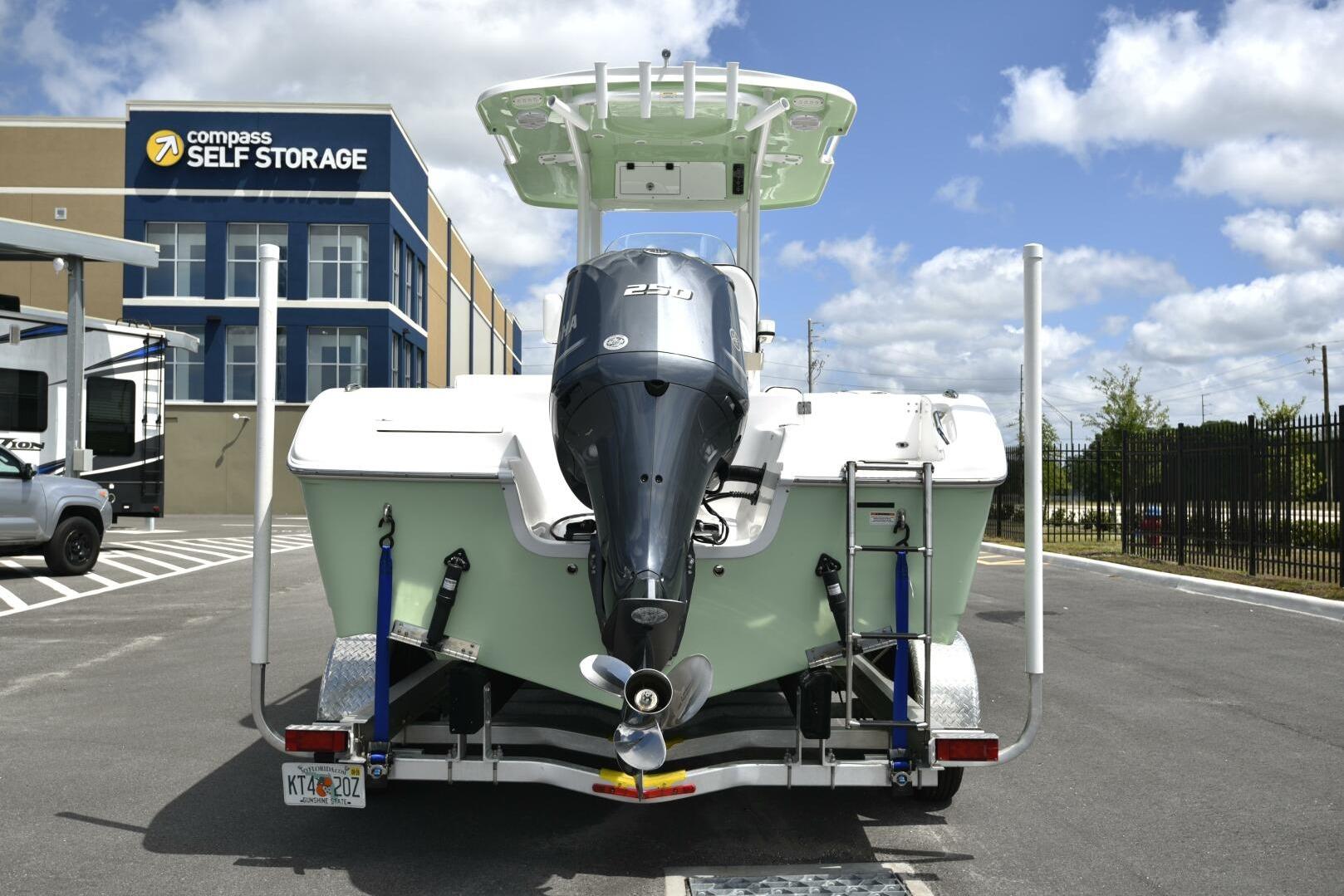 2023 Sea Pro 239 Deep V CC boat on trailer near storage facility.
