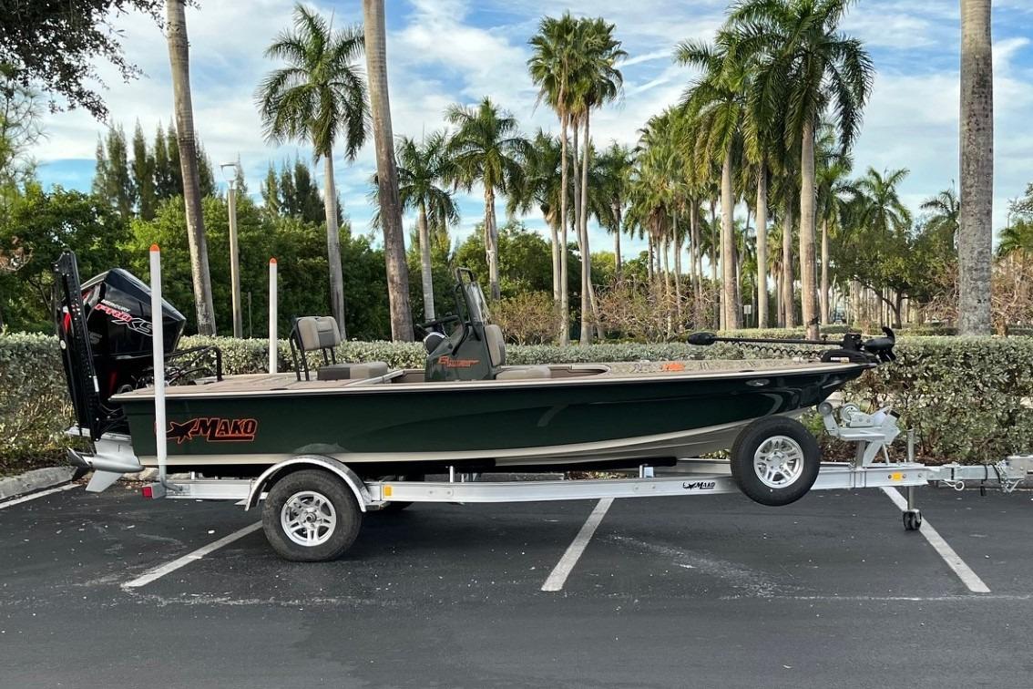 2026 Mako 18 Pro Skiff Backwater Edition on trailer, parked near palm trees.
