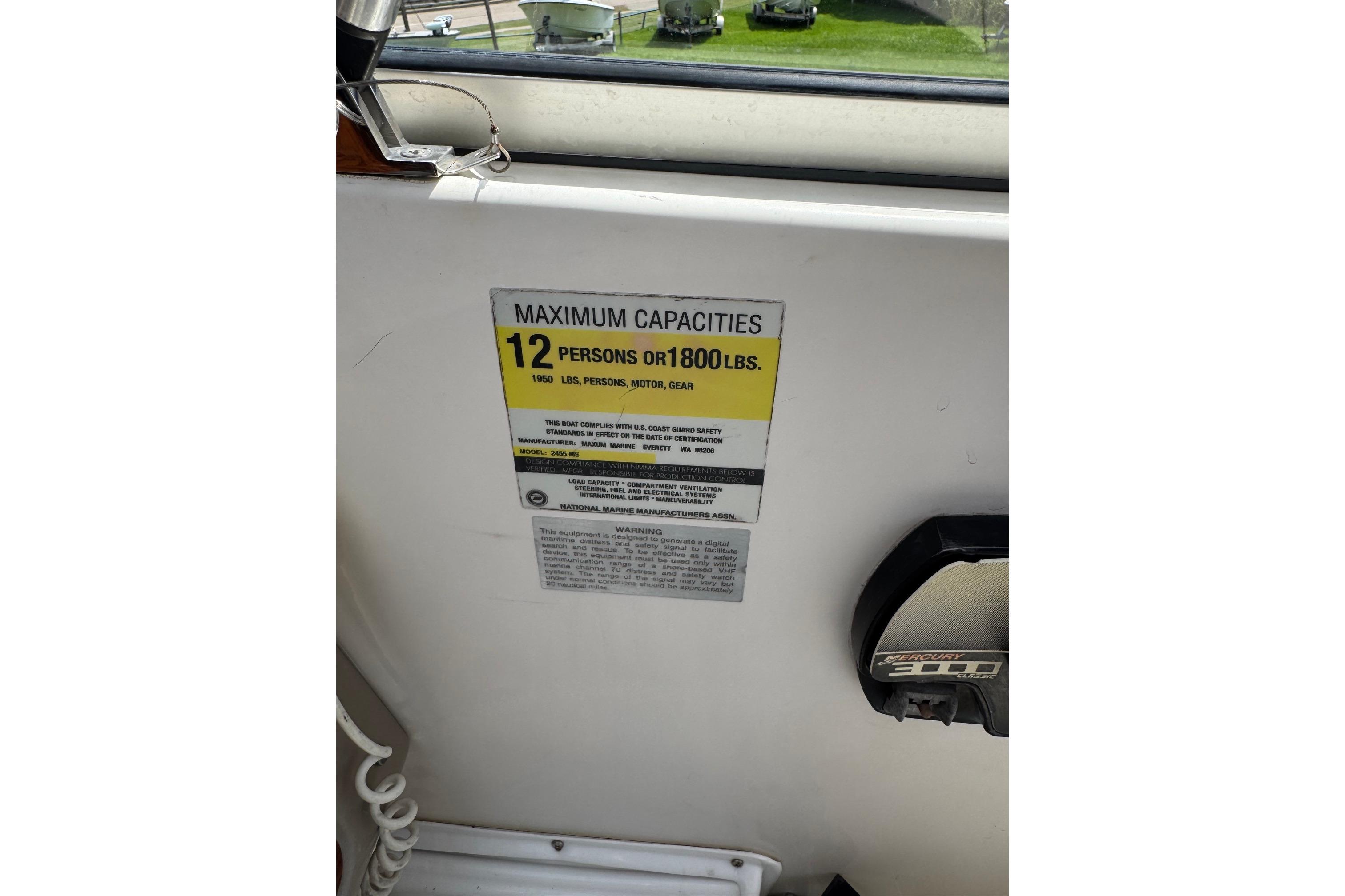 Boat capacity label on 2000 Maxum 2400 SCR, indicating 12 persons or 1800 lbs limit.