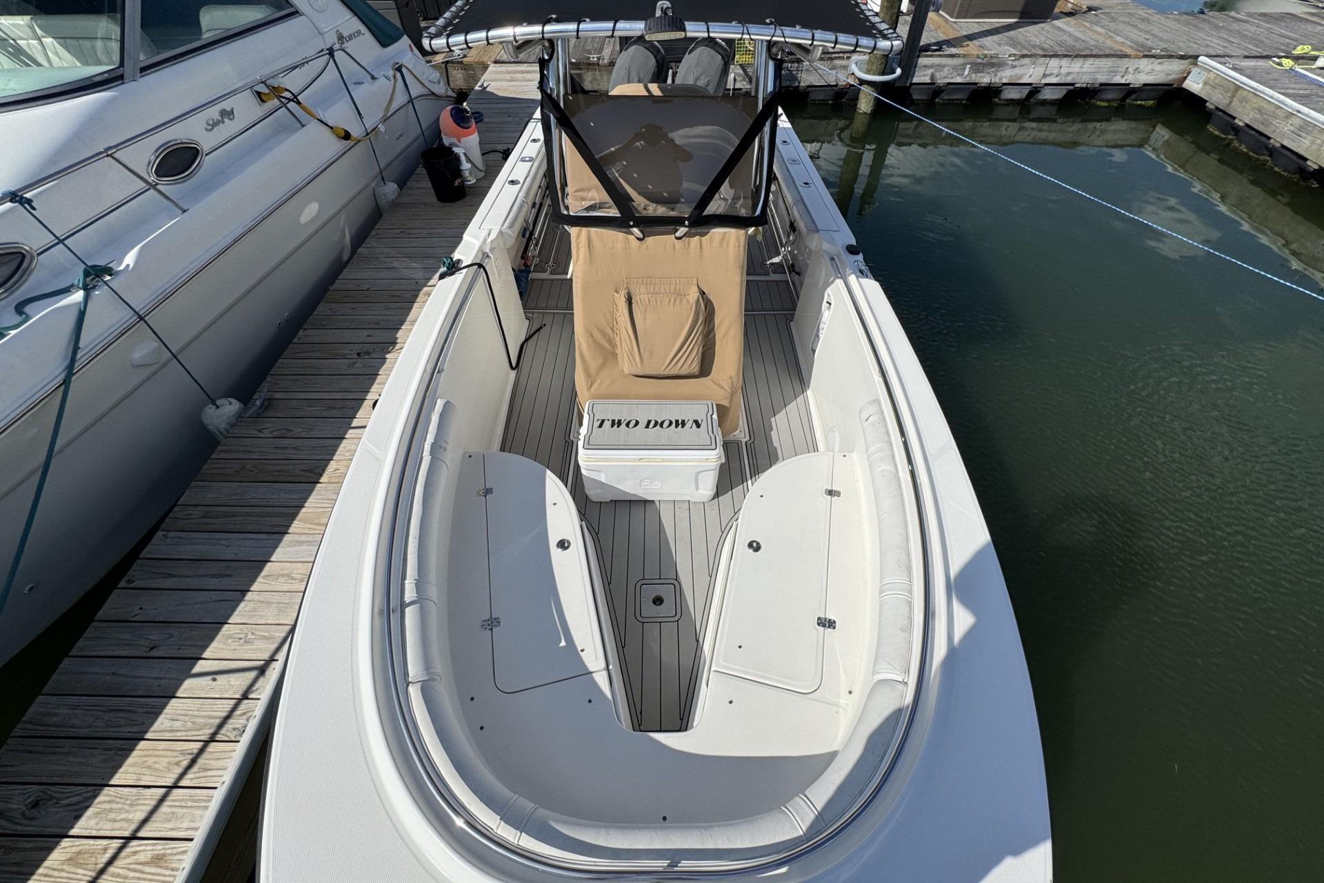 2007 Edgewater 245CC boat docked, featuring spacious deck and seating area.