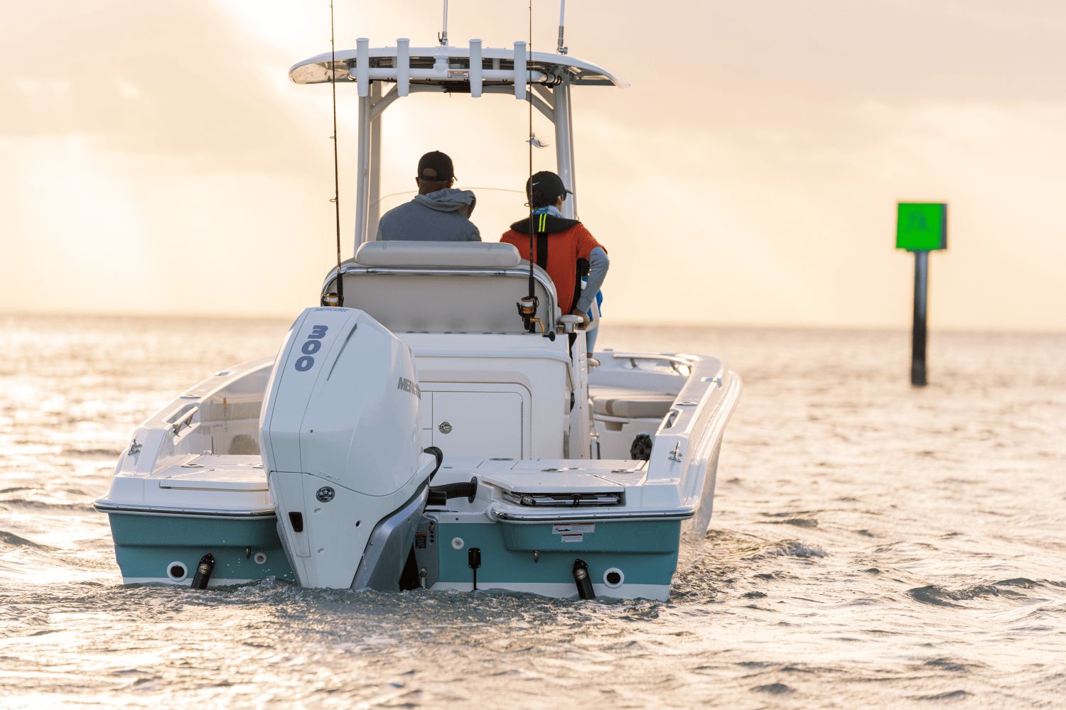 Two people ride a Boston Whaler 25DA boat on calm waters.