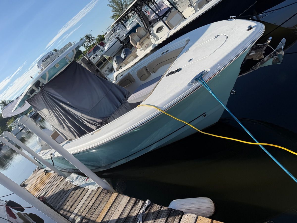 A 2019 NauticStar 28 XS docked. It features a blue hull design and a T-top.
