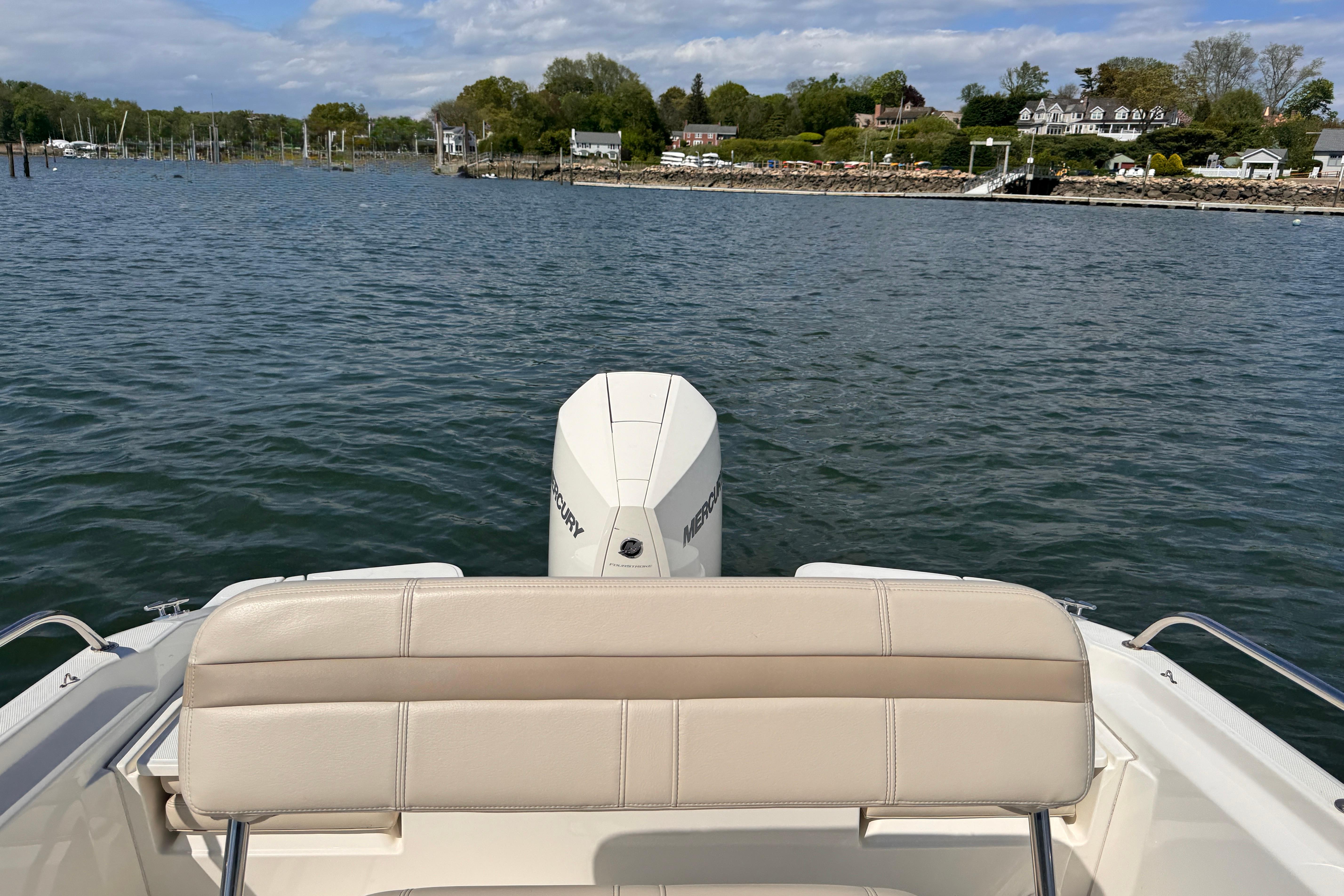 2022 Boston Whaler 220 Dauntless boat on water, scenic shoreline view.