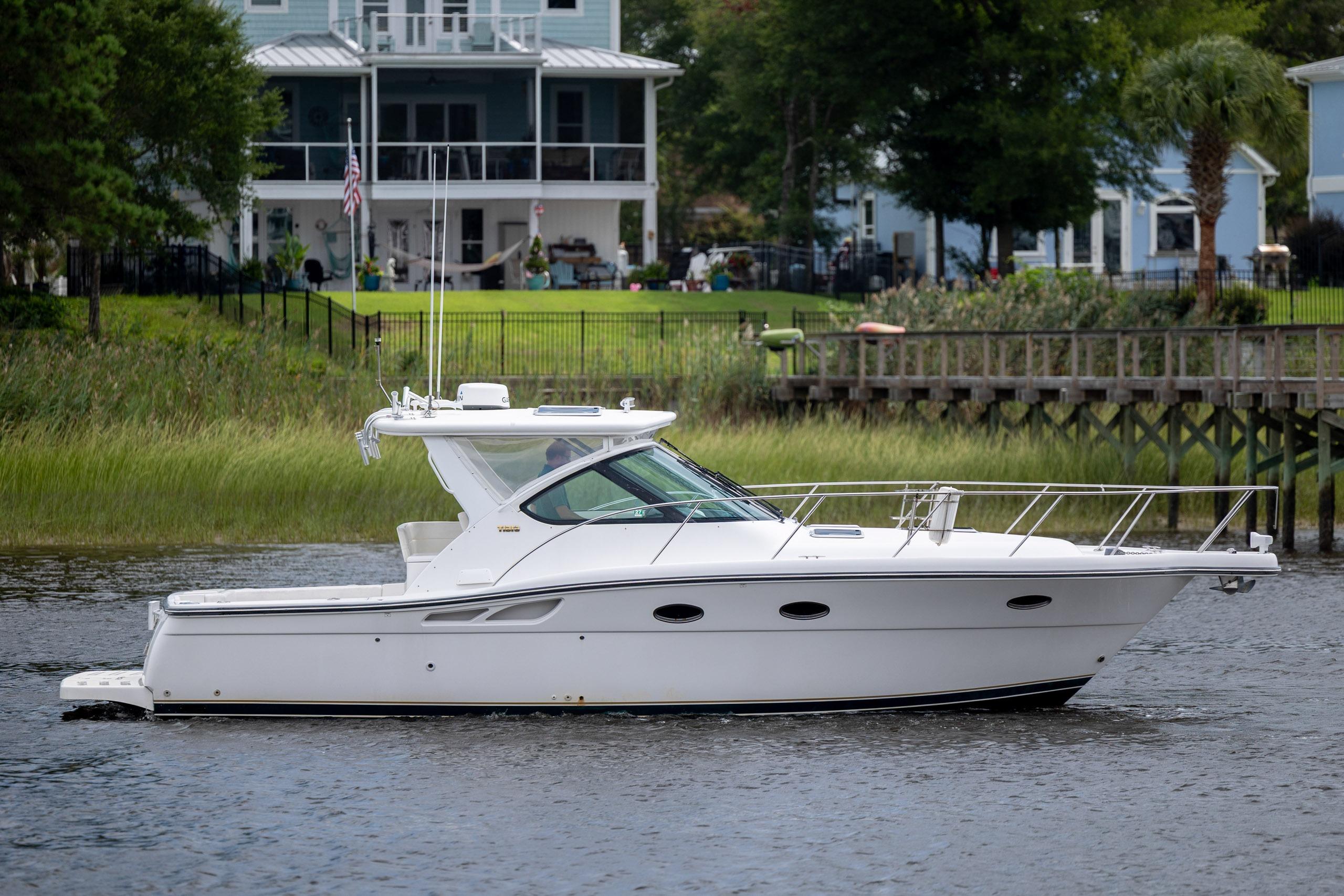 2004 Tiara Yachts 3200 Open cruising on a serene waterfront near residential homes.