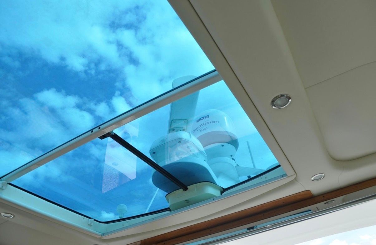 View through a glass roof showing the sky and boat equipment.