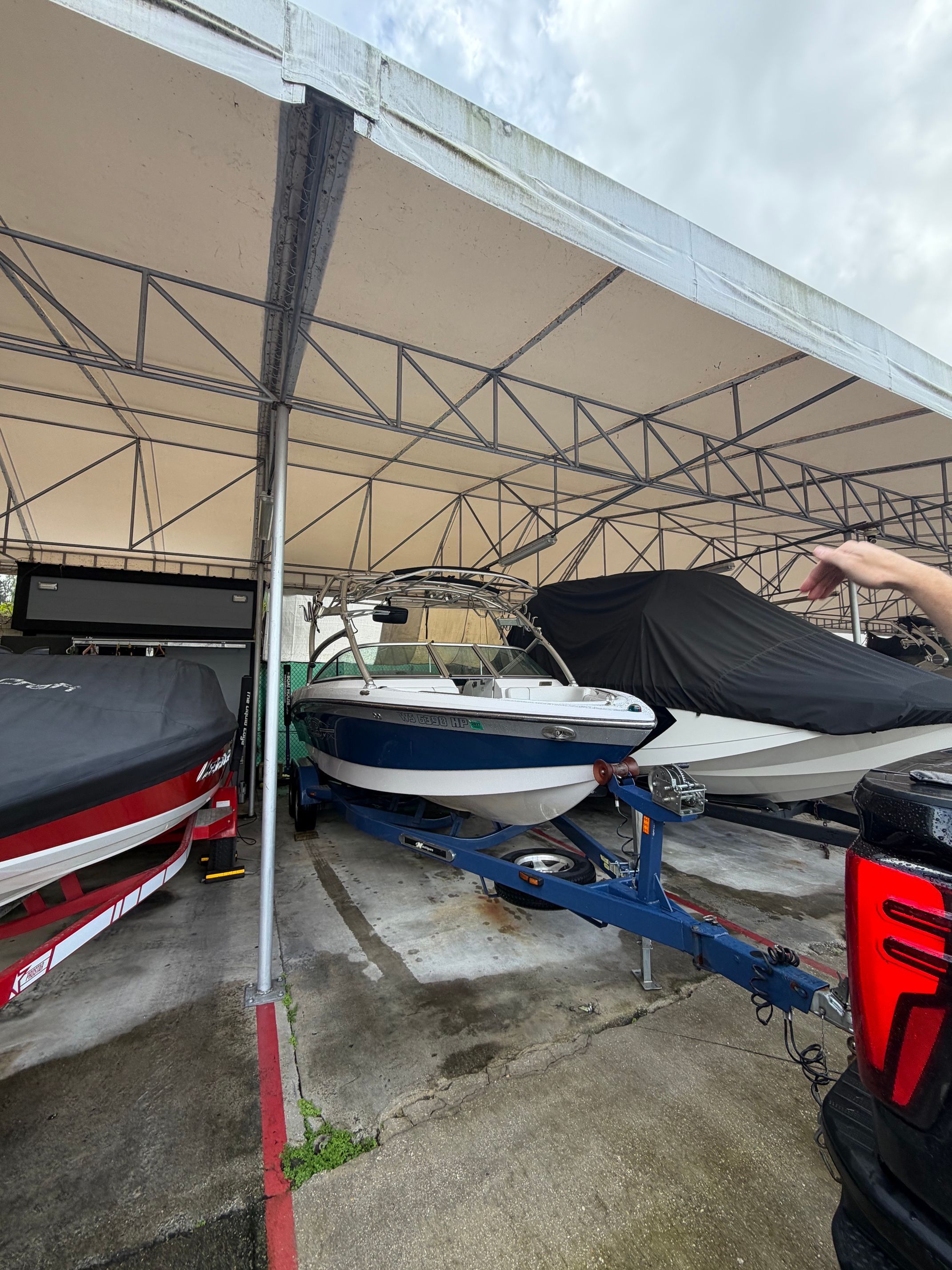 2008 Nautique 236 Team Edition boat under cover in marina.