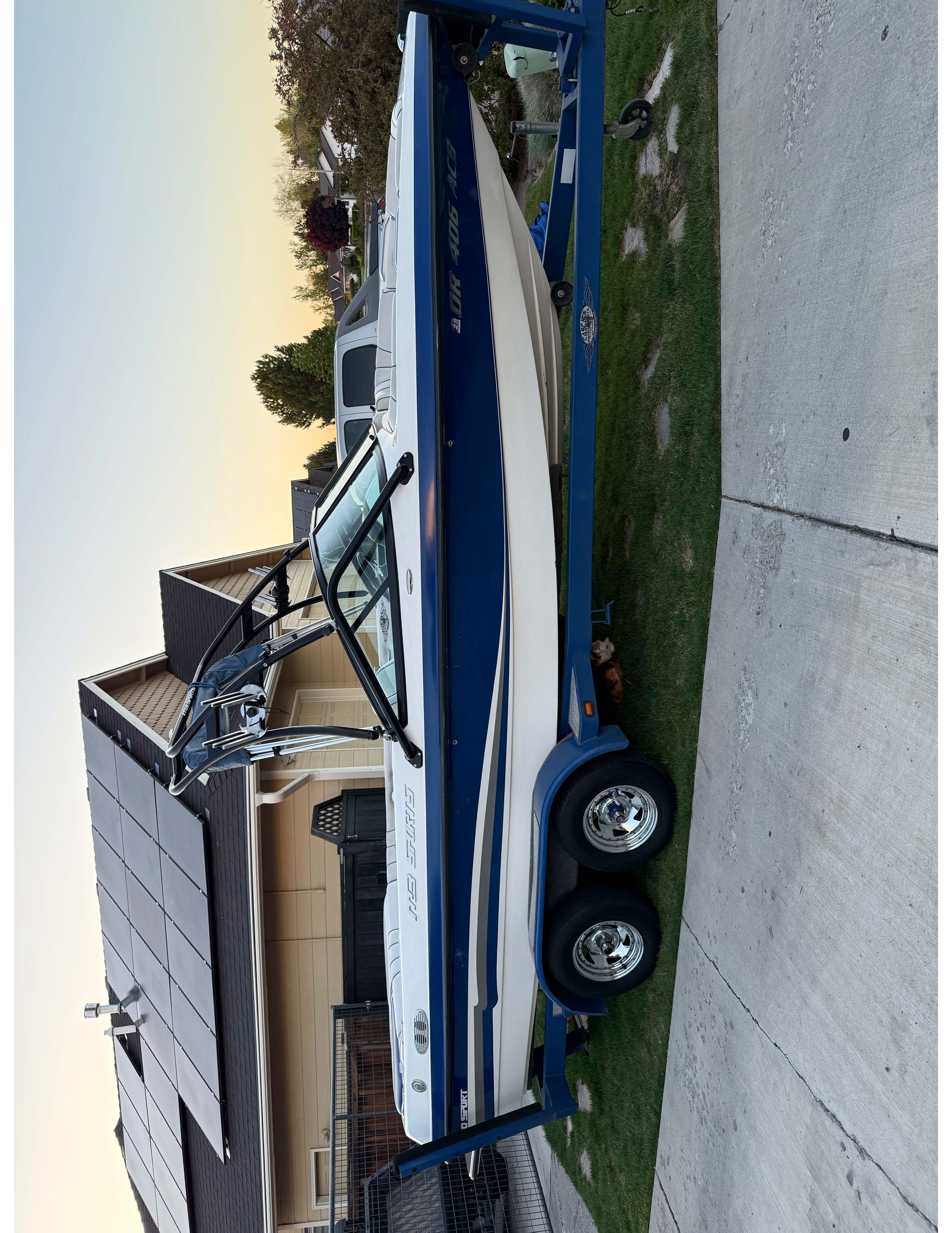 2004 MB Sports 220 boat on trailer parked by house.