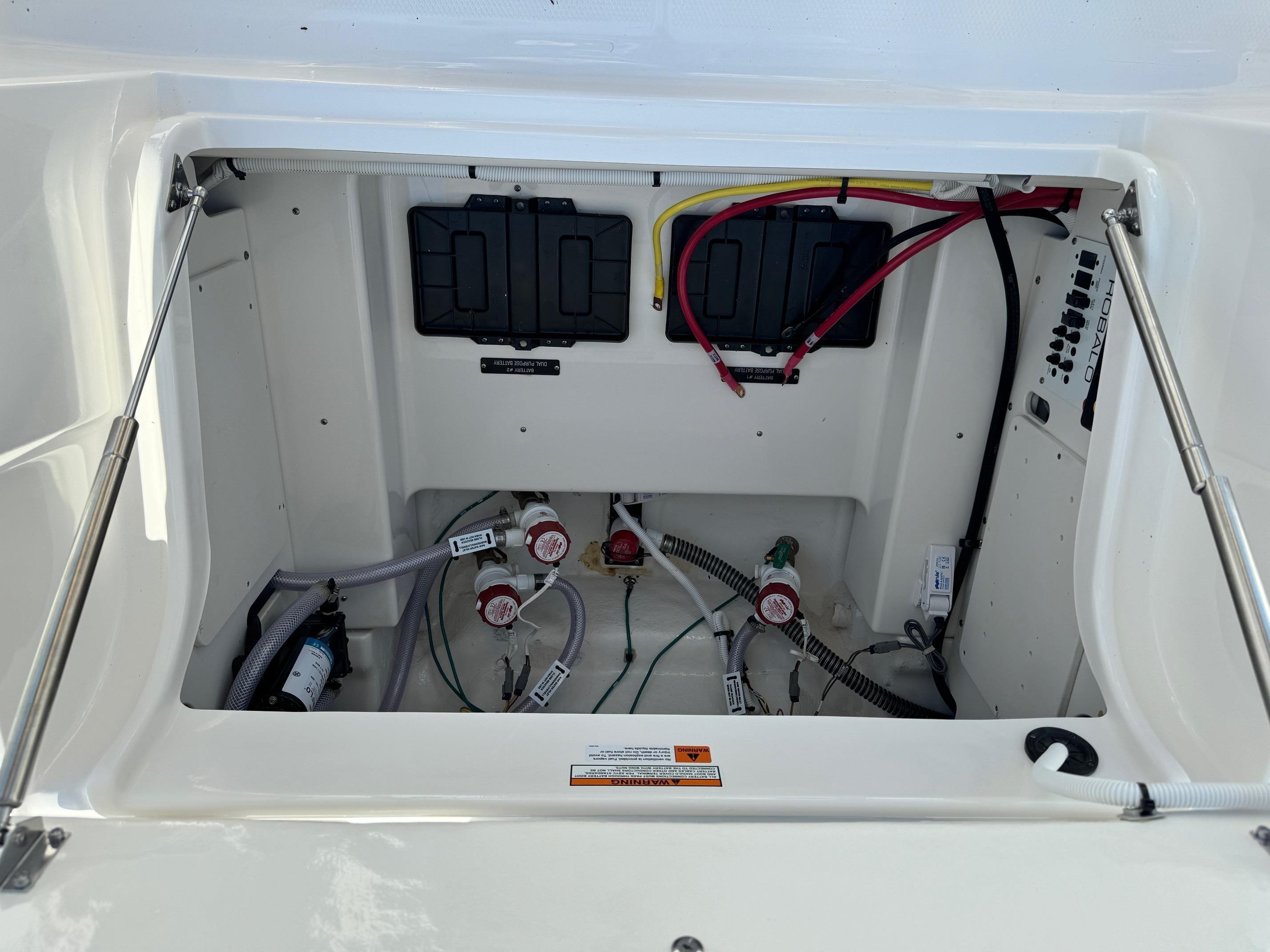 2025 Robalo R246 CAYMAN boat compartment with wiring and control systems.