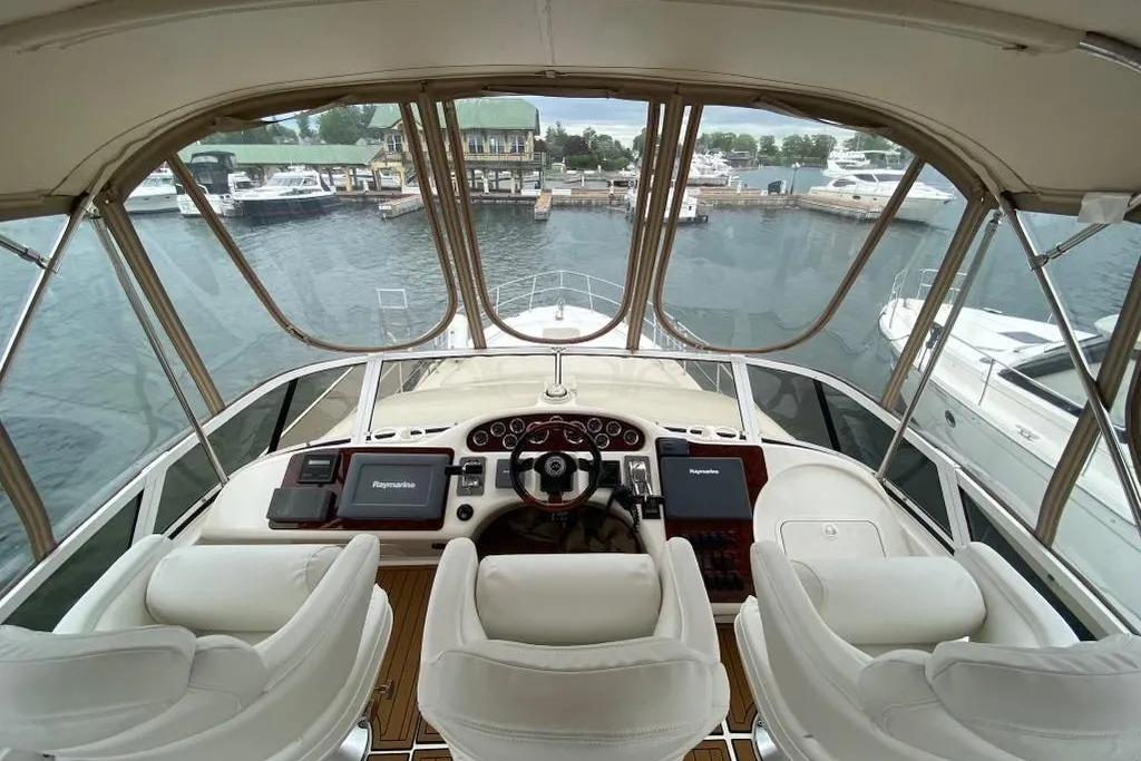 Helm of 2000 Sea Ray 400 Sedan Bridge yacht with marina view.