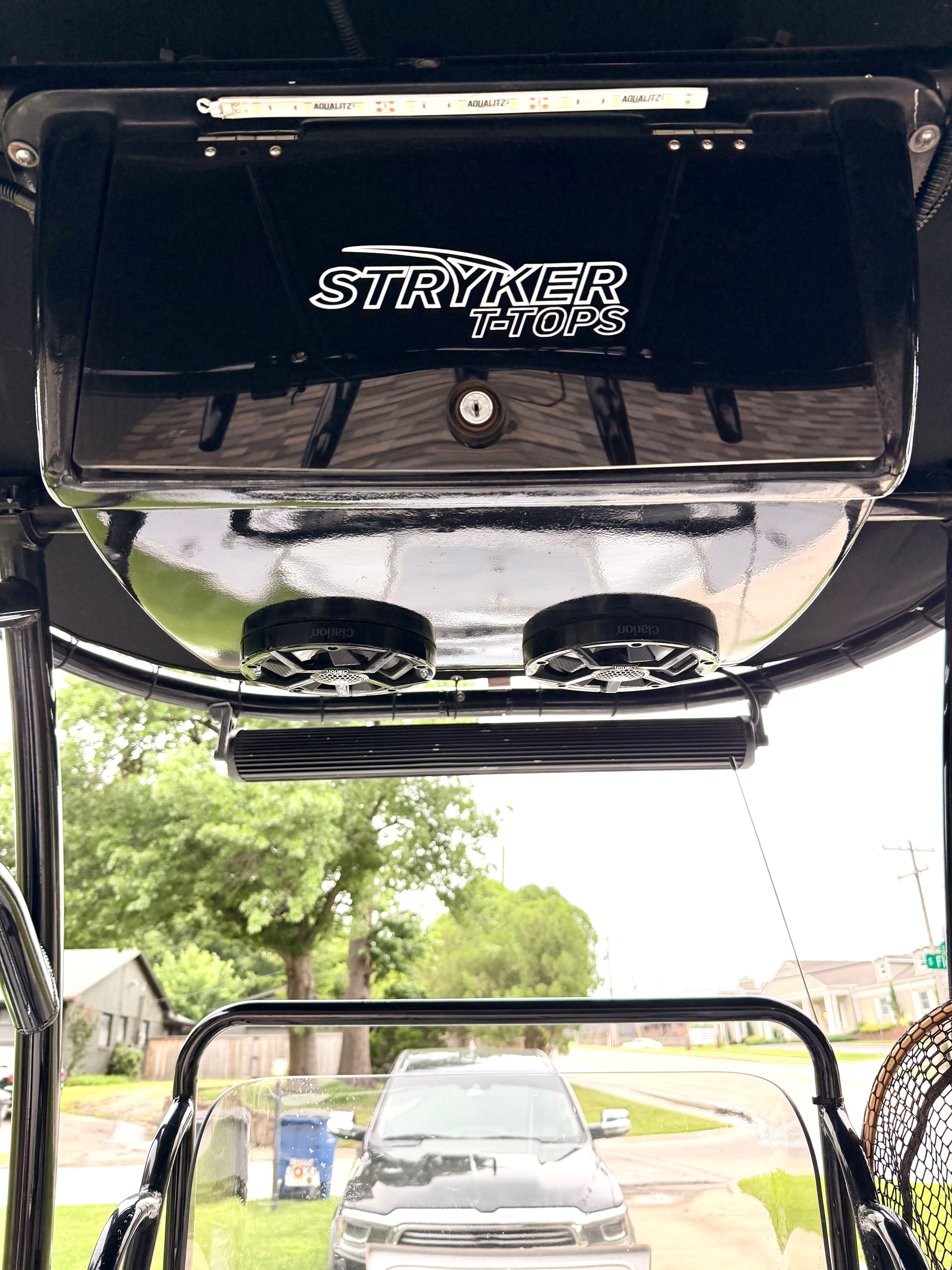 View from a boat with a black T-top and speakers underneath.
