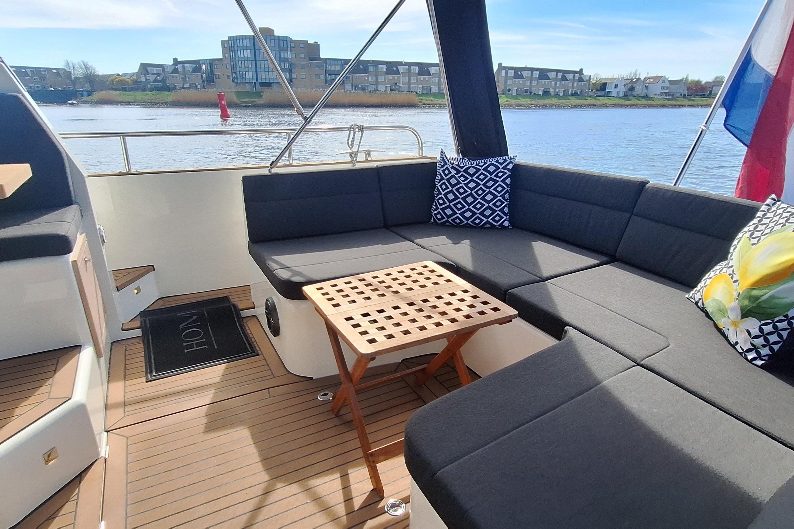 Luxurious 2023 Antaris X boat interior with cushioned seating and decorative pillows.