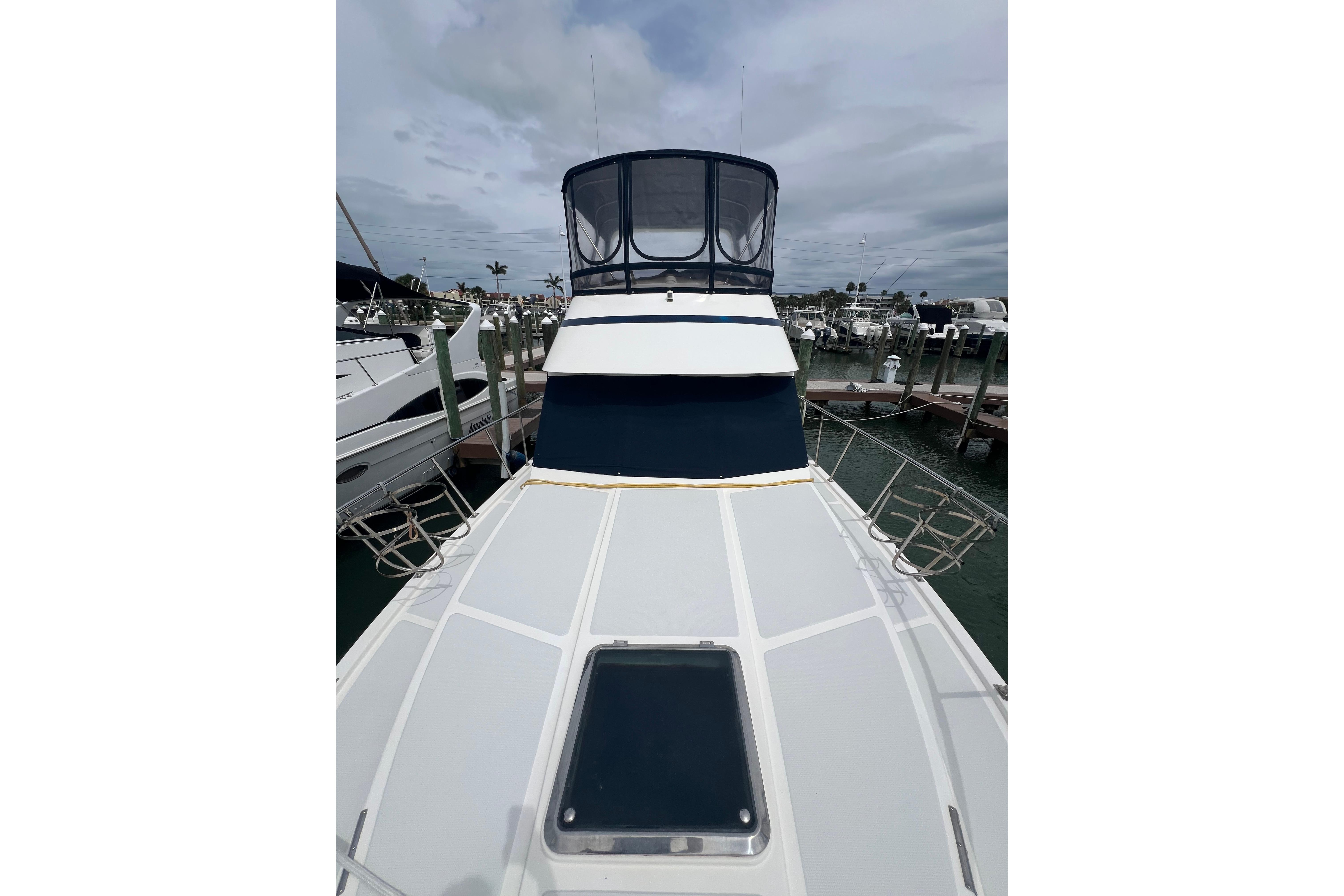2007 Heritage East 36 Sundeck Trawler docked, showcasing spacious deck and enclosed helm.