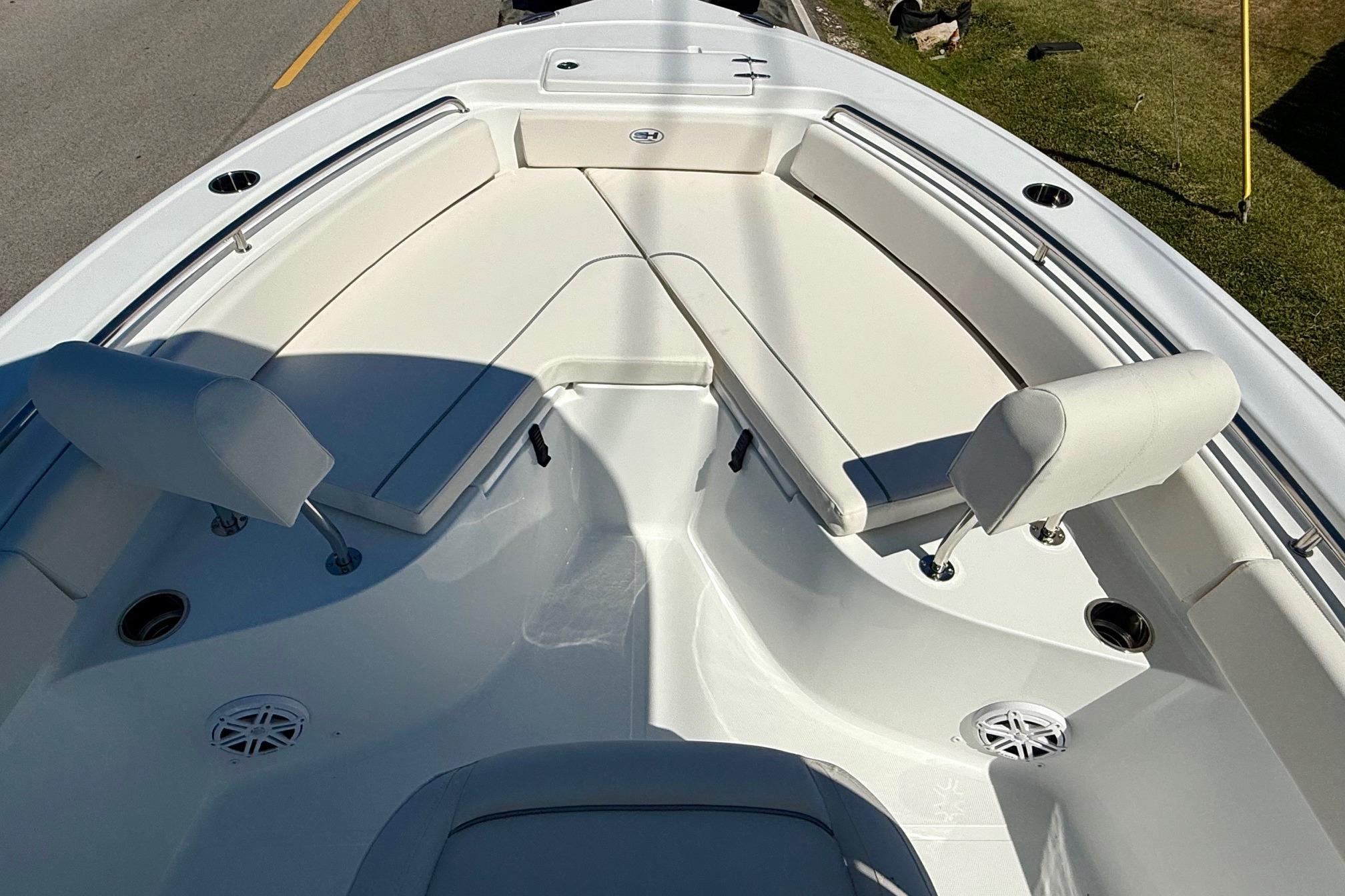 2026 Sea Hunt Ultra 229 boat interior with white cushioned seating and cup holders.