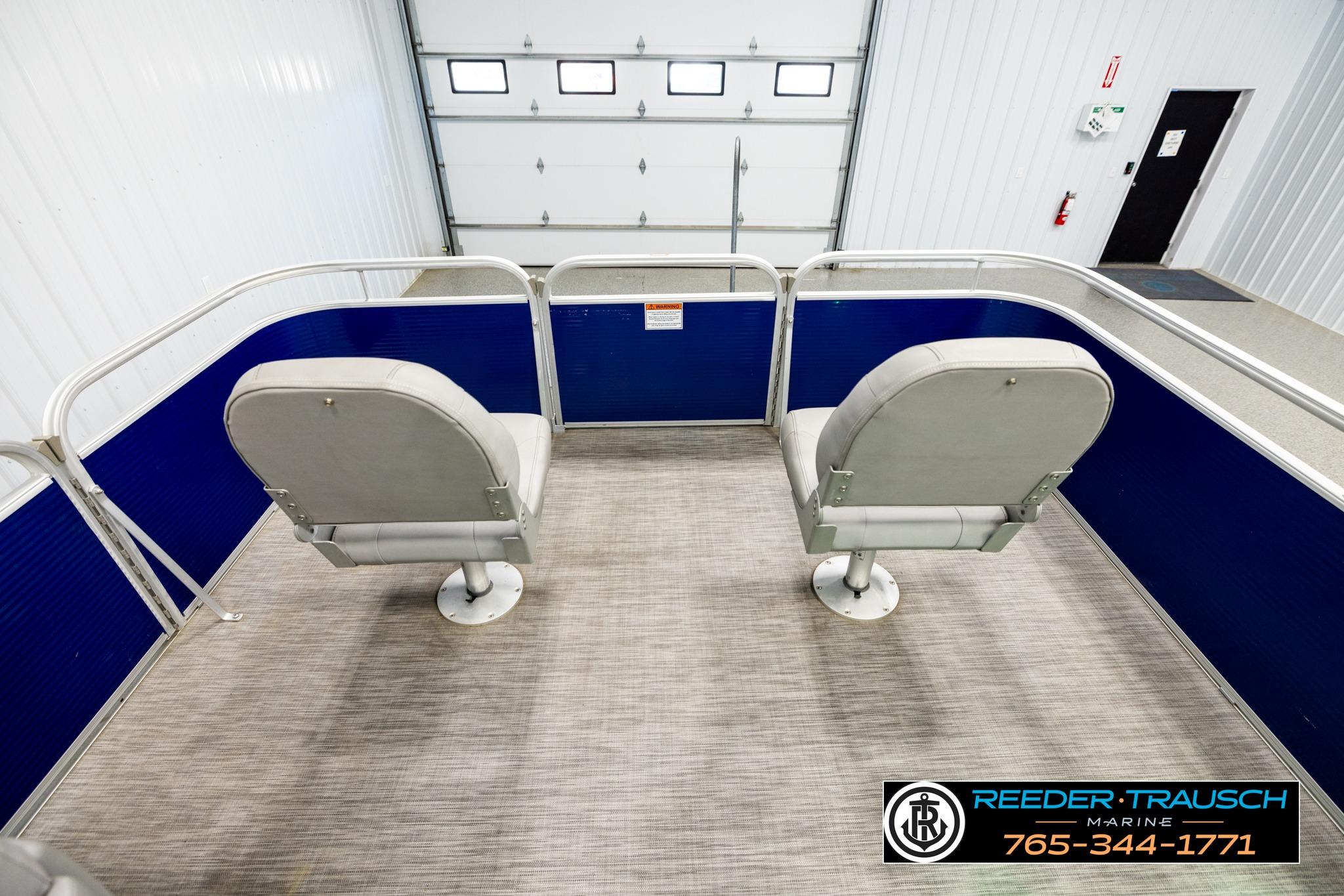 2021 Bennington 20 SV pontoon boat interior with two gray seats in a showroom.