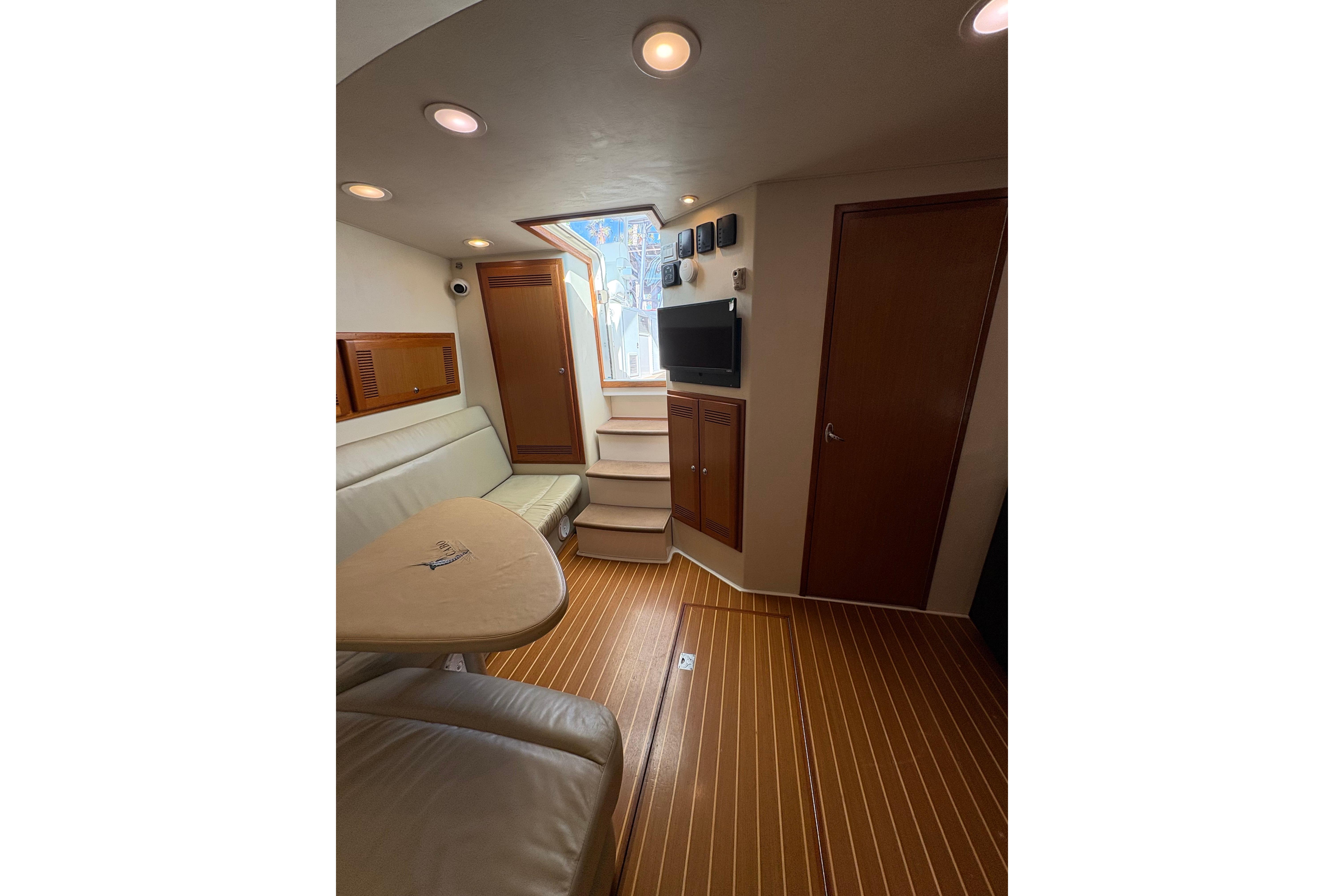 Interior of 2004 Cabo 40 Hardtop Express yacht with seating, table, and TV.