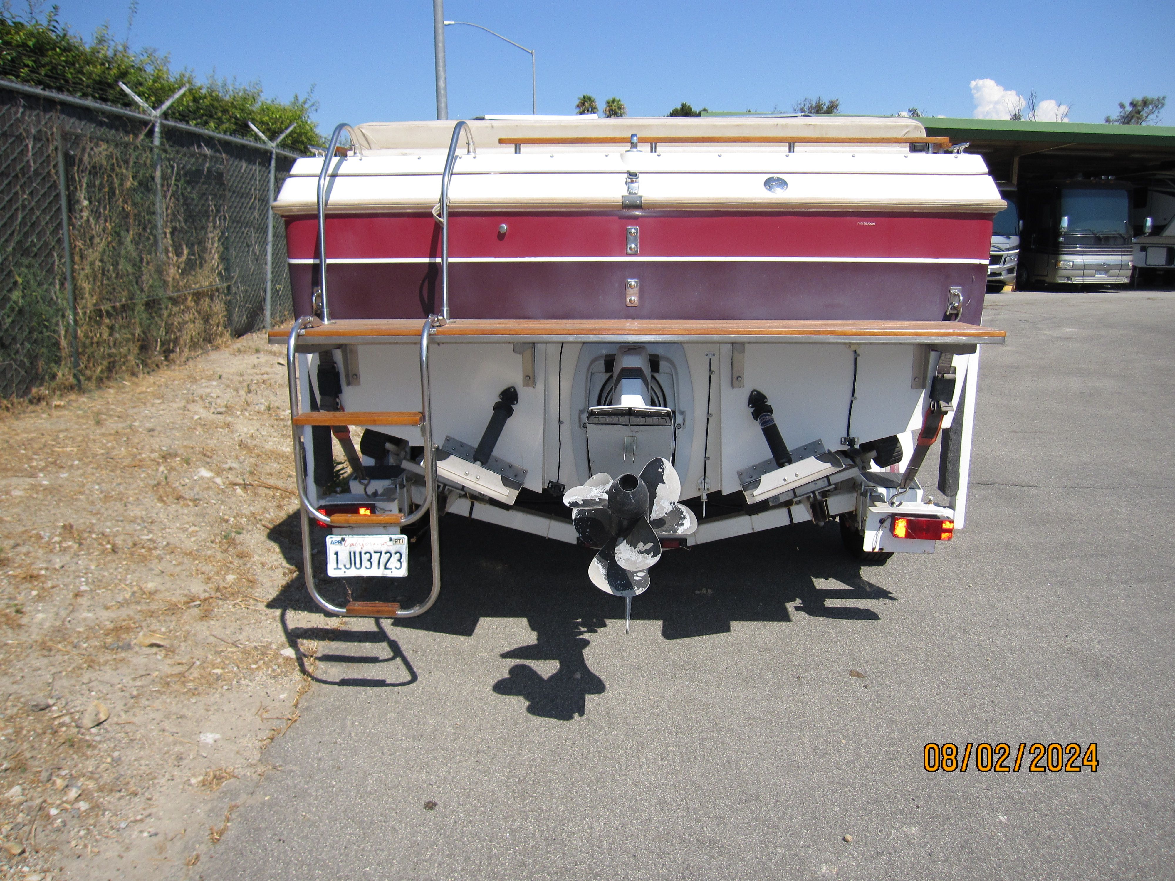Rear view of a 1990 Cobalt Bowrider Classic boat in a parking lot.
