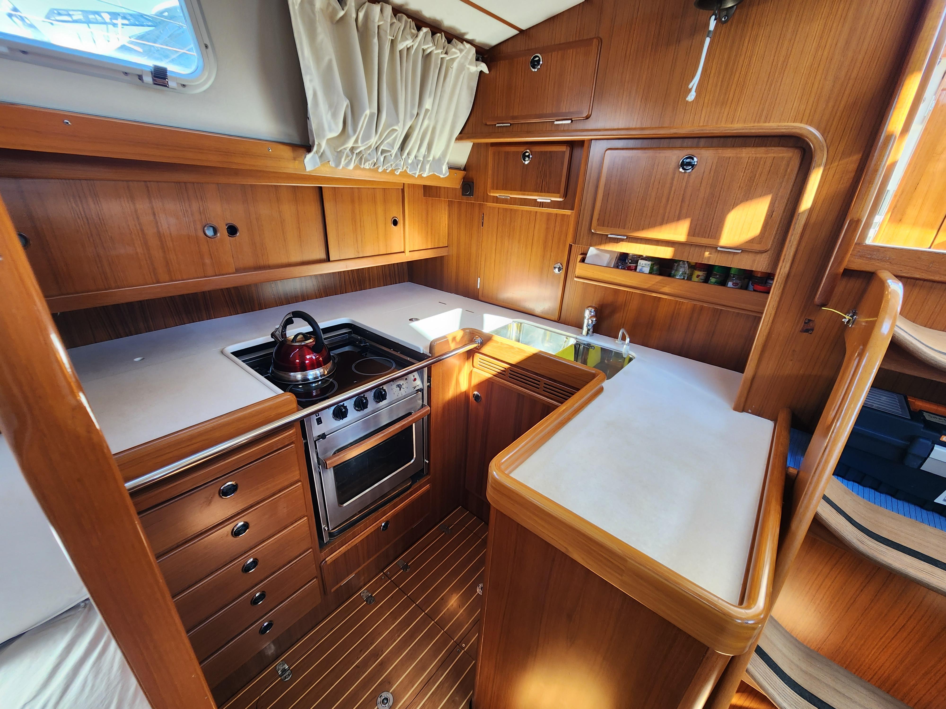 Hallberg-Rassy 53 yacht kitchen interior, 2006 model, featuring wood cabinetry and modern appliances.