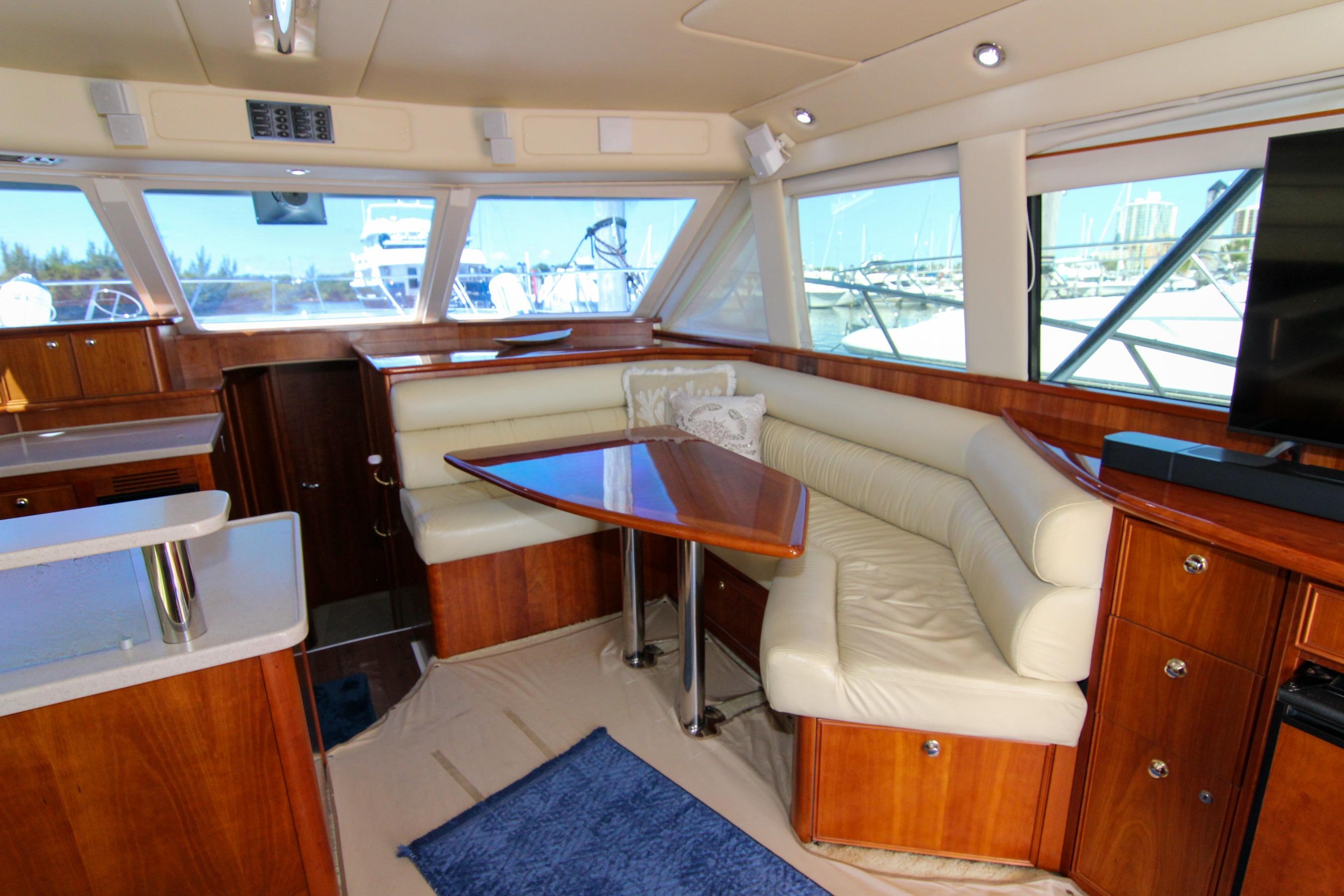 Luxurious interior of 2006 Riviera 47 Open Flybridge yacht with leather seating and wooden finishes.
