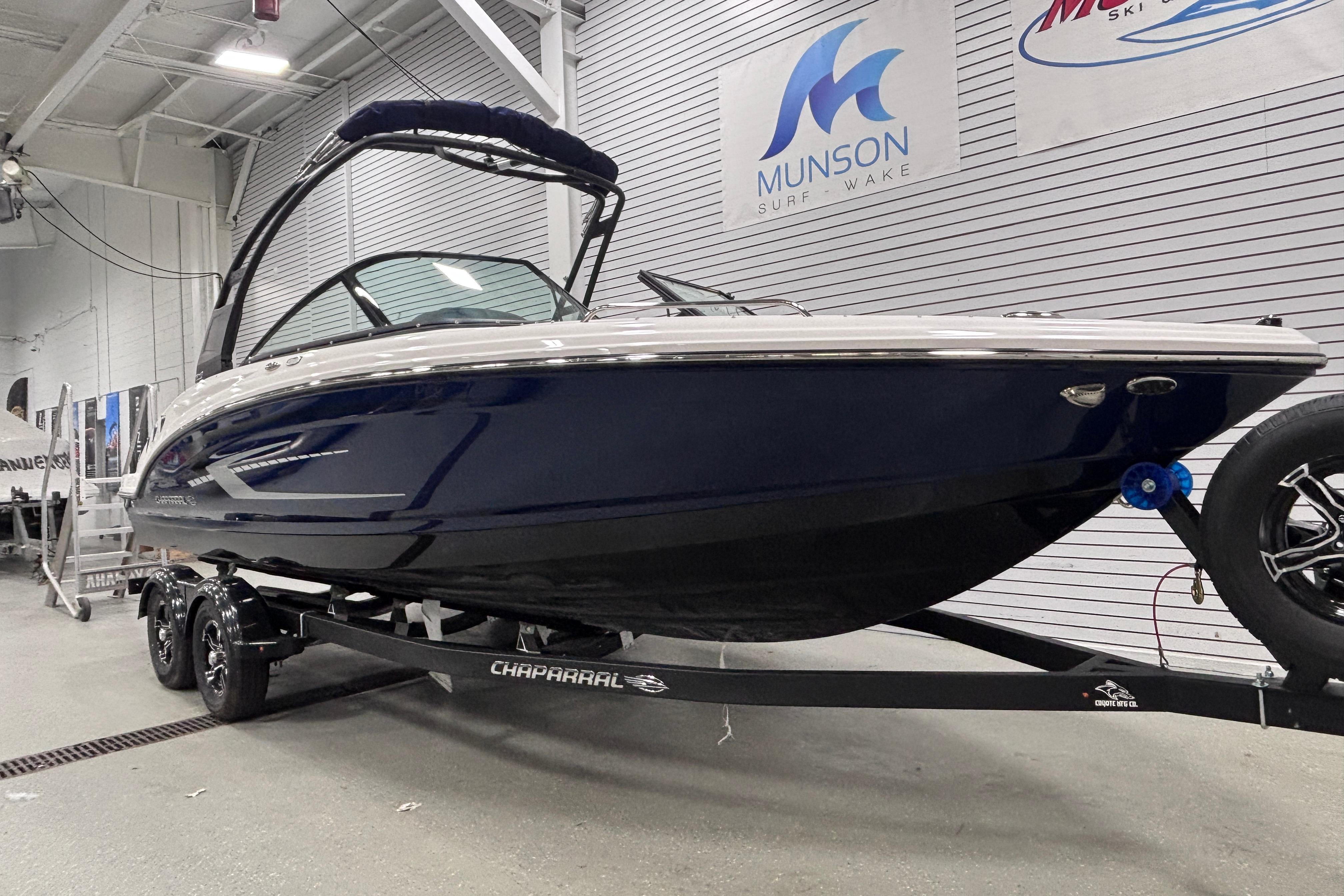 2026 Chaparral 23 SSi boat on trailer in showroom, sleek design, Munson Surf & Wake.