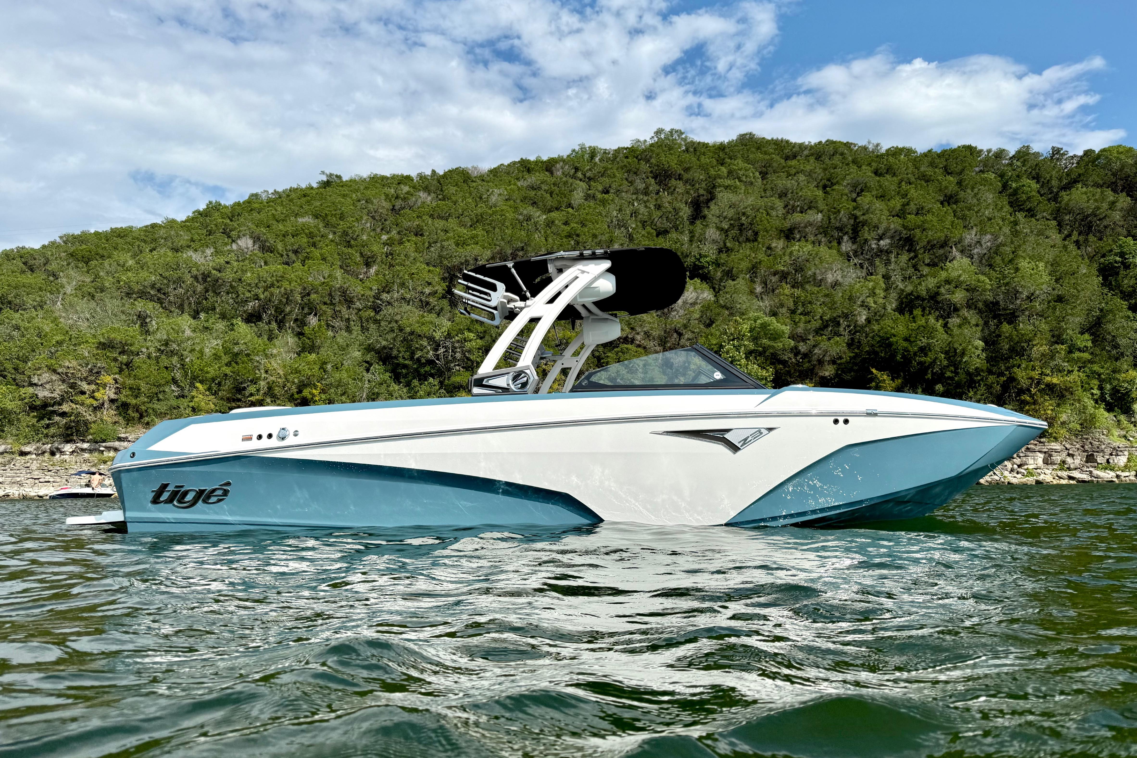 2021 Tige Z3 boat on water with lush green forest background.