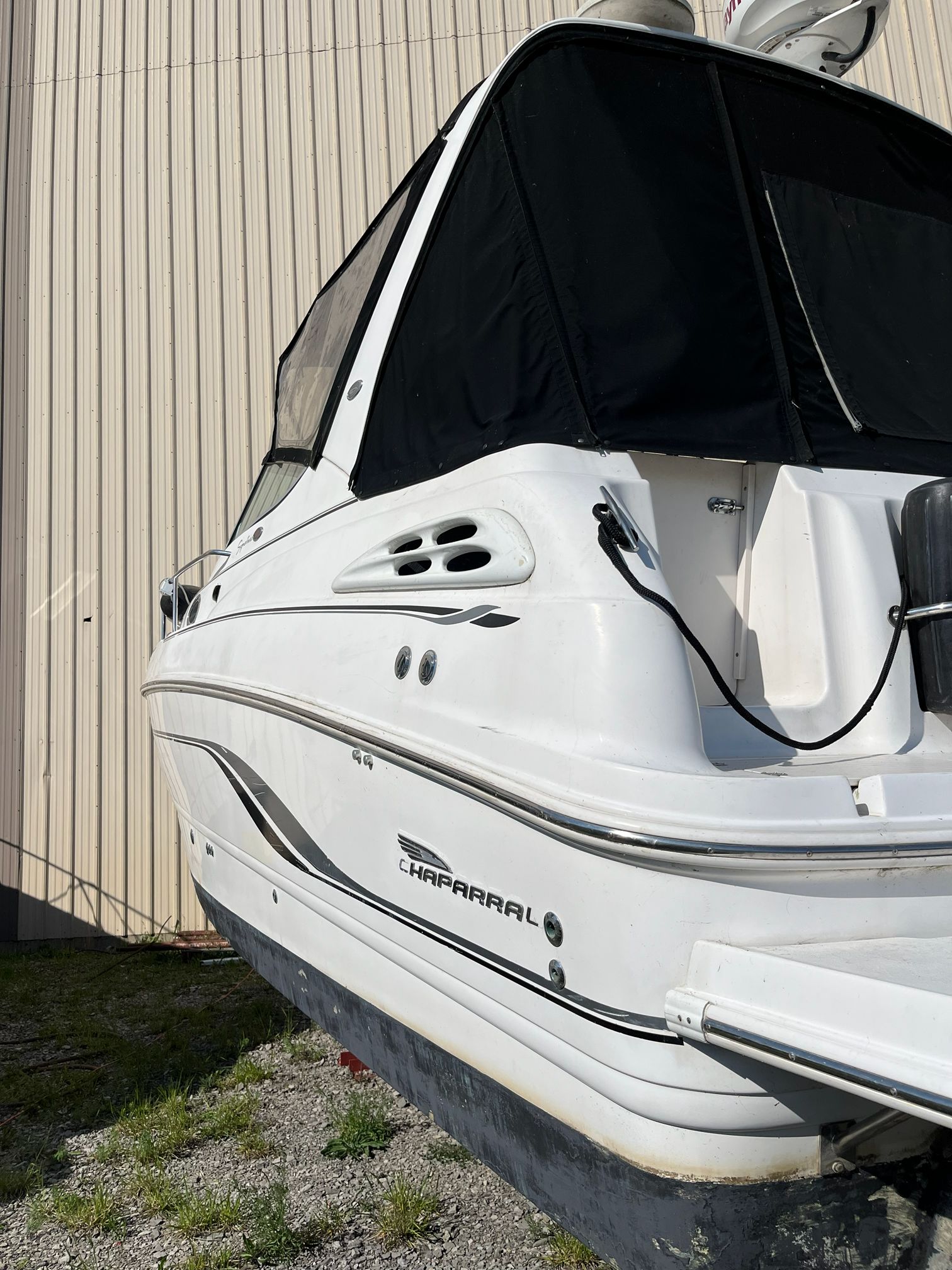 2000 Chaparral Signature boat with black canopy, side view.