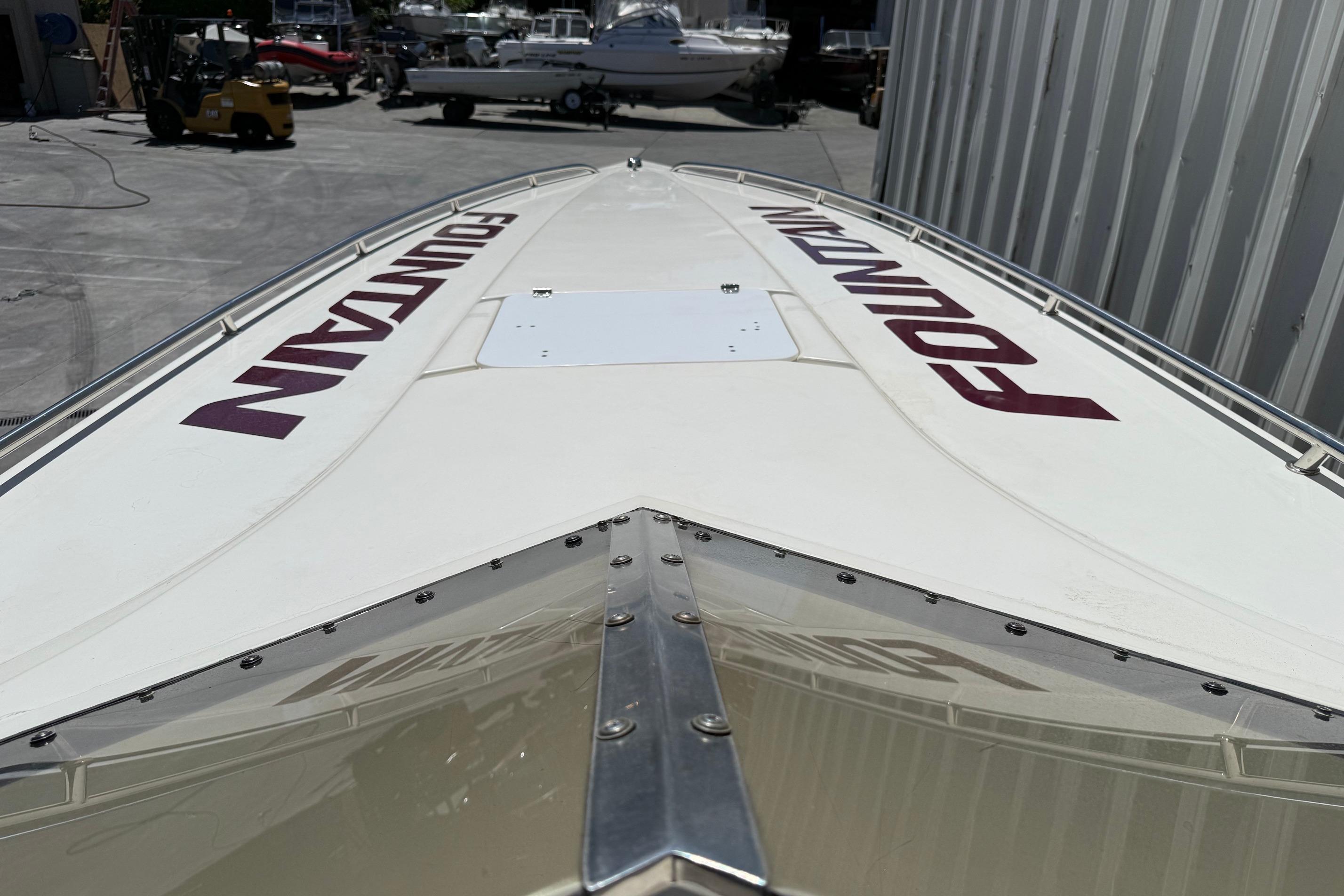 1998 Fountain 35 Lightning boat, white with red lettering, docked near storage facility.