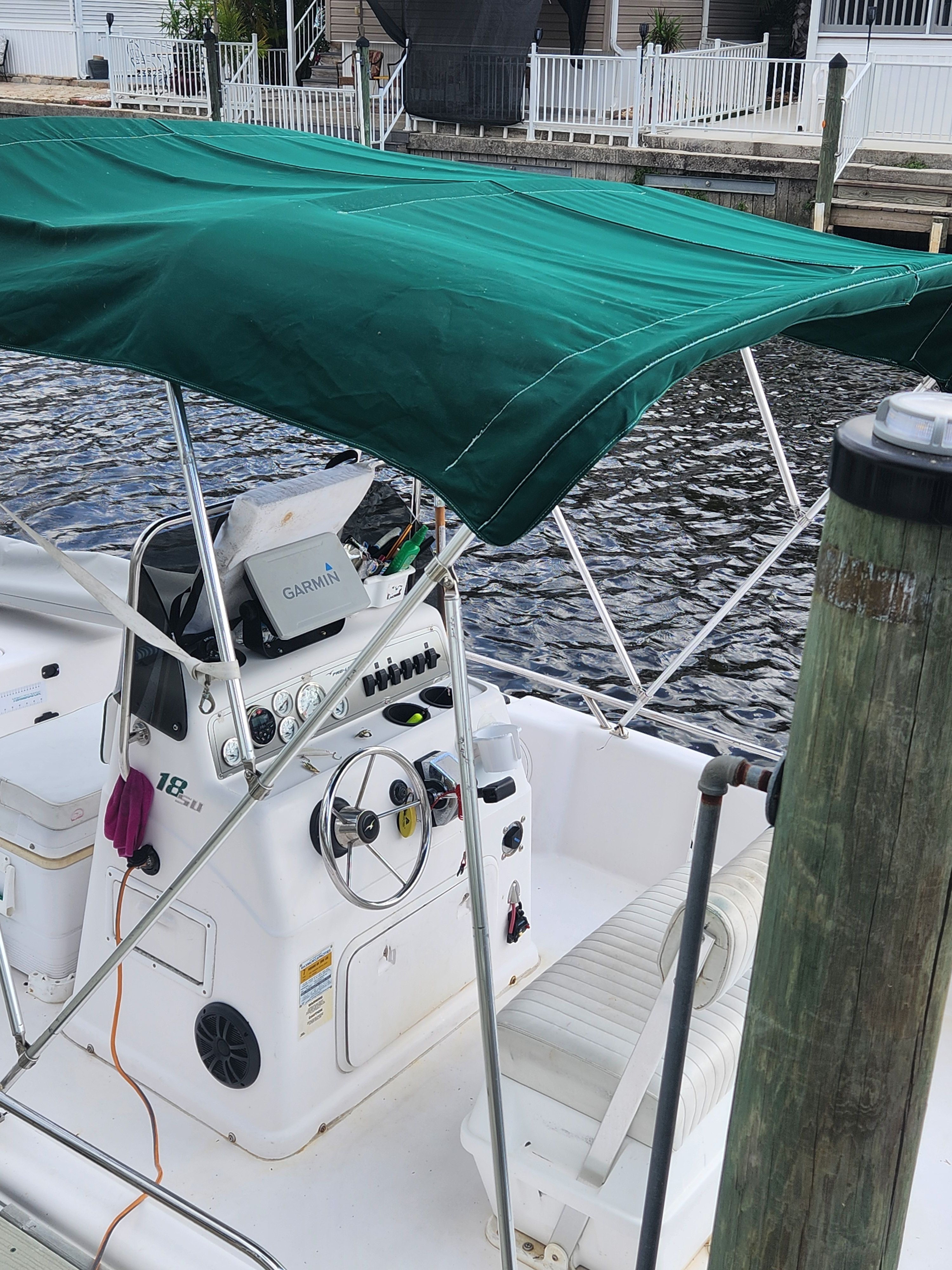 2001 Pro-Line 18.8 Sport with green canopy, docked by the water.