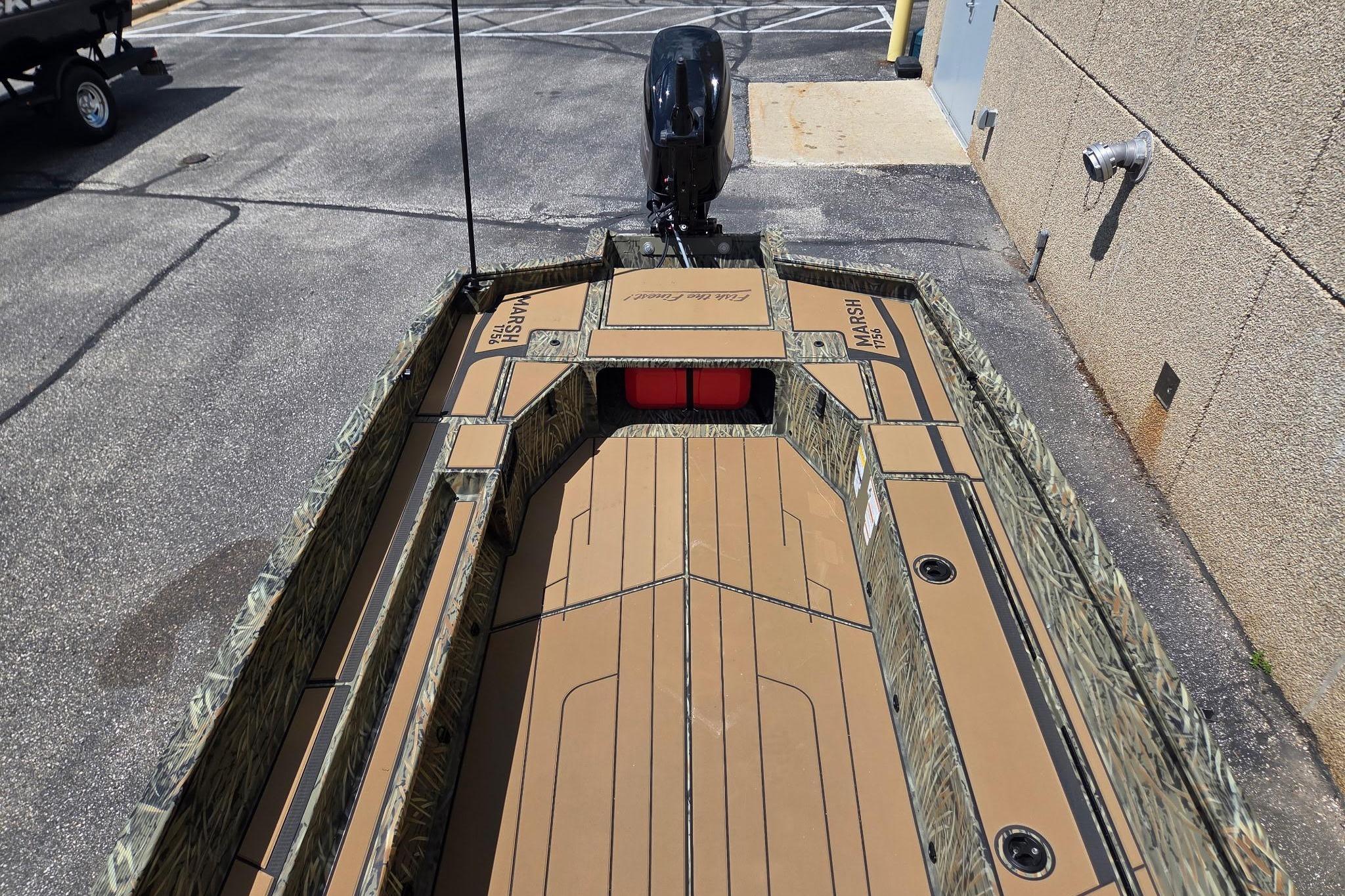 2026 Tracker Grizzly 1756 T Marsh boat with camouflage design, parked outdoors.