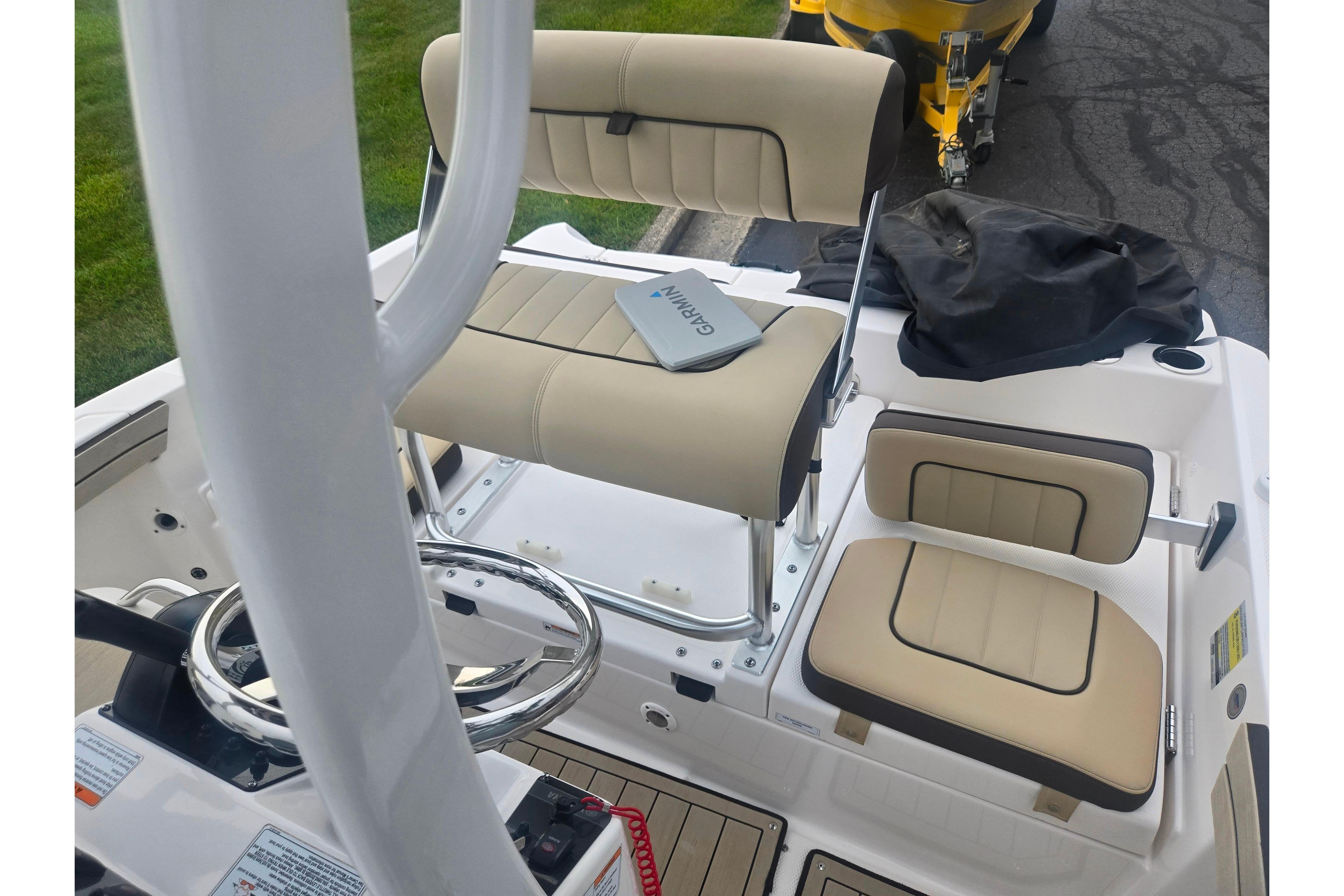 2022 Yamaha Boats 195 FSH Sport interior with beige seating and steering wheel.