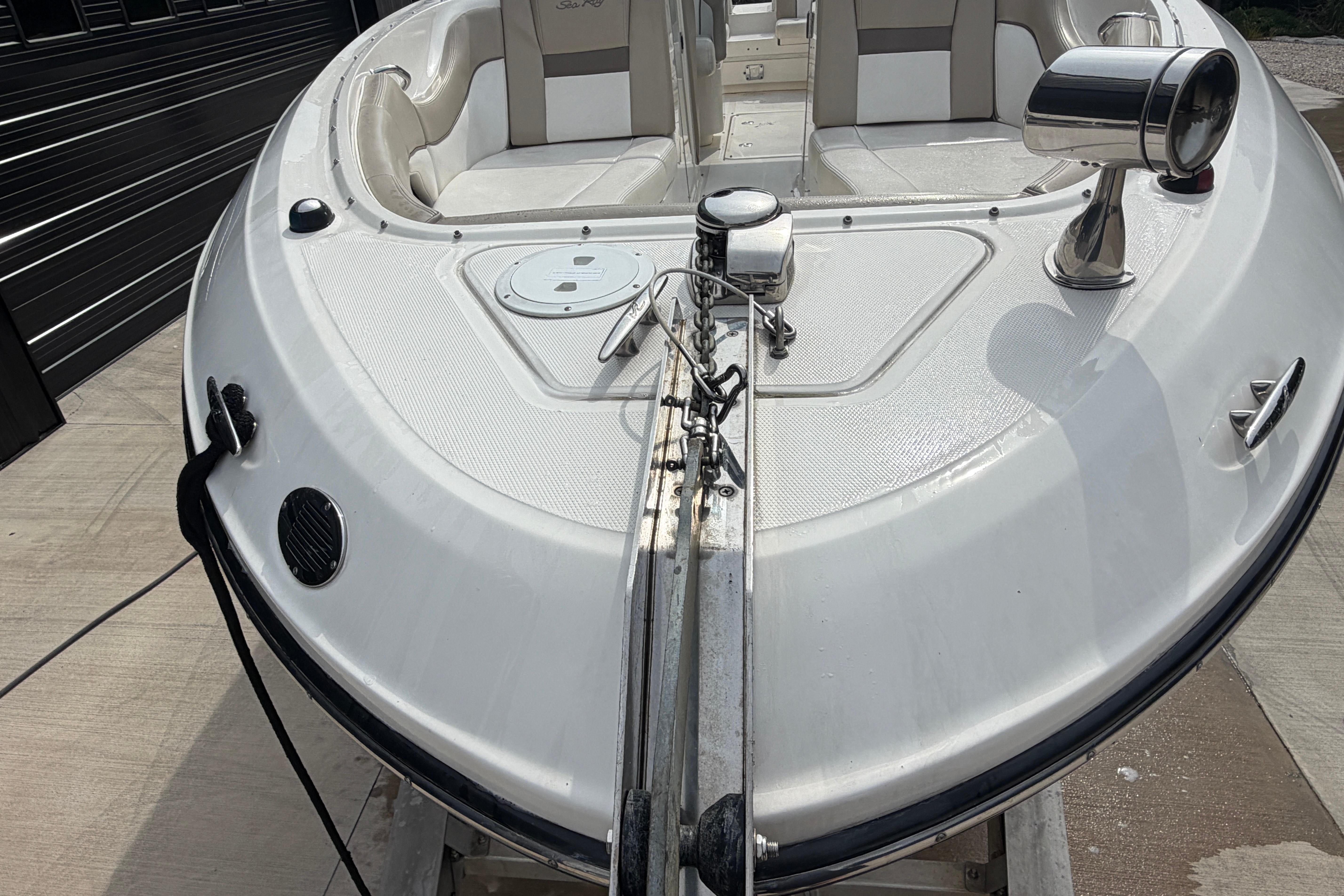 2013 Sea Ray 300 SLX boat bow with seating and anchor, docked on concrete.