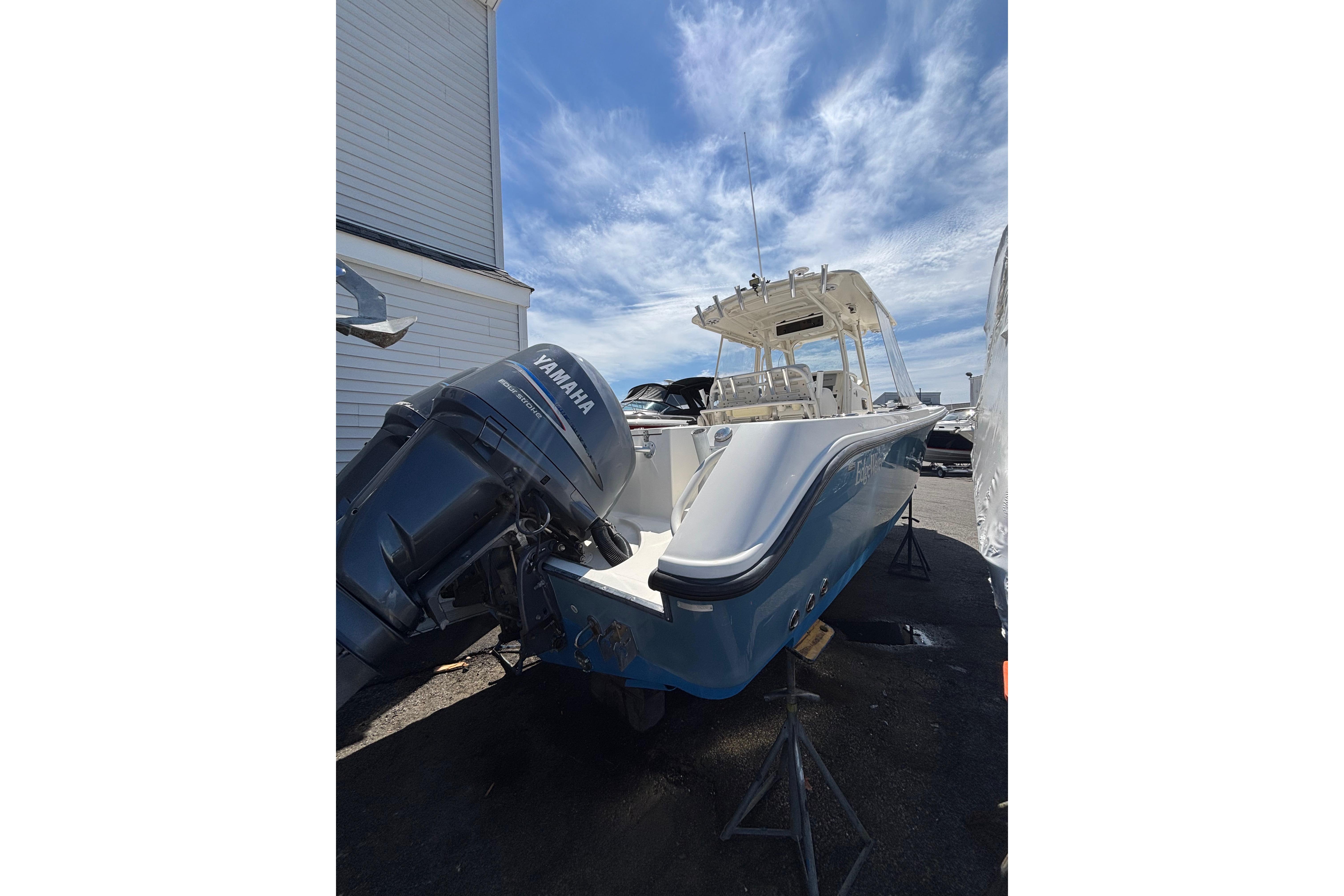 2006 Edgewater 318CC boat with Yamaha engine, parked outdoors under a clear blue sky.