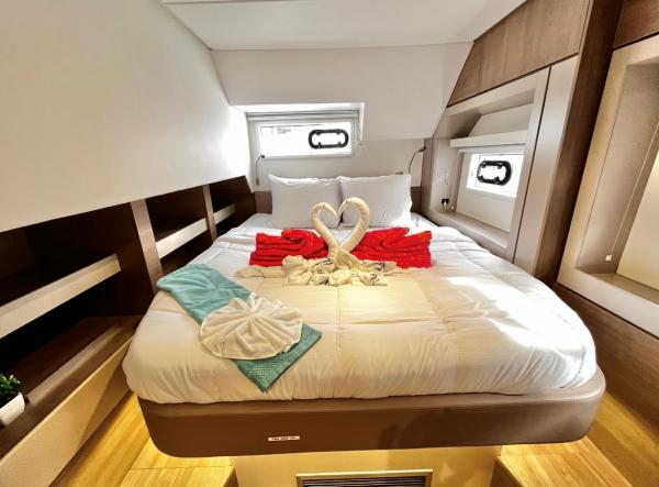 Luxurious Bali 4.6 yacht cabin with elegant bedding and towel swans, 2023 model.