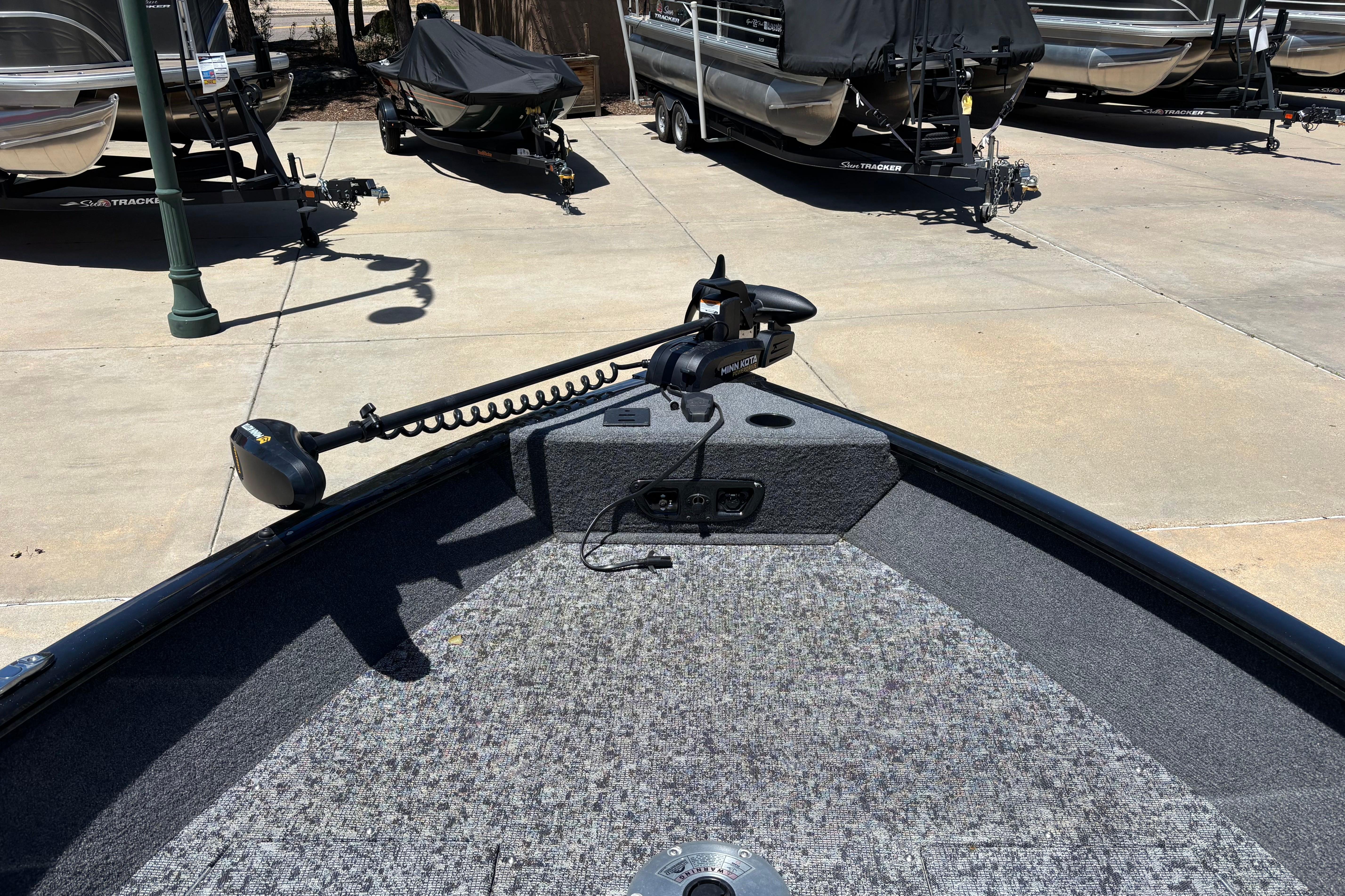 2025 Tracker Pro Guide V-175 Combo boat with trolling motor in a parking area.