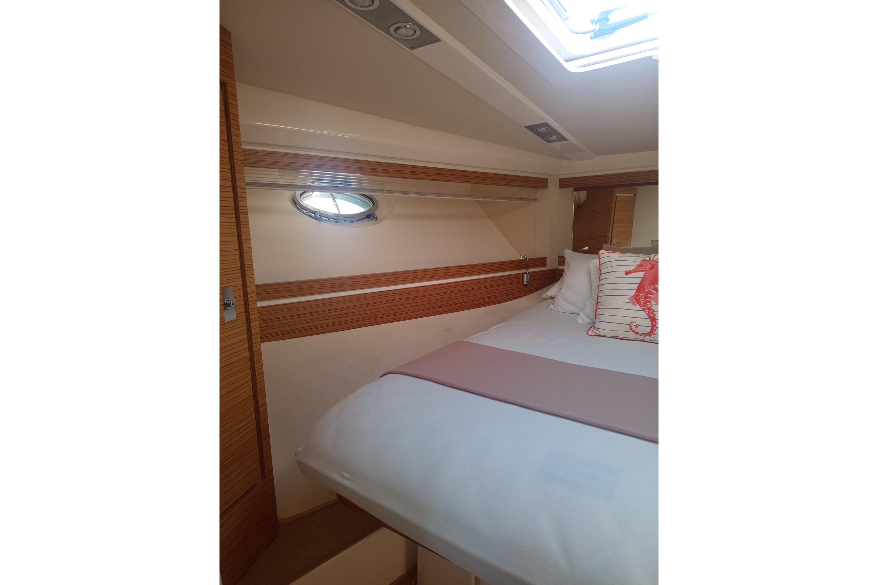 Interior cabin of 2008 Itama 40 yacht with cozy bed and seahorse pillow.