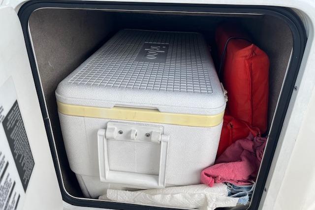 Storage compartment in a 2003 Sea Ray 260 Sundancer with cooler and life jacket.