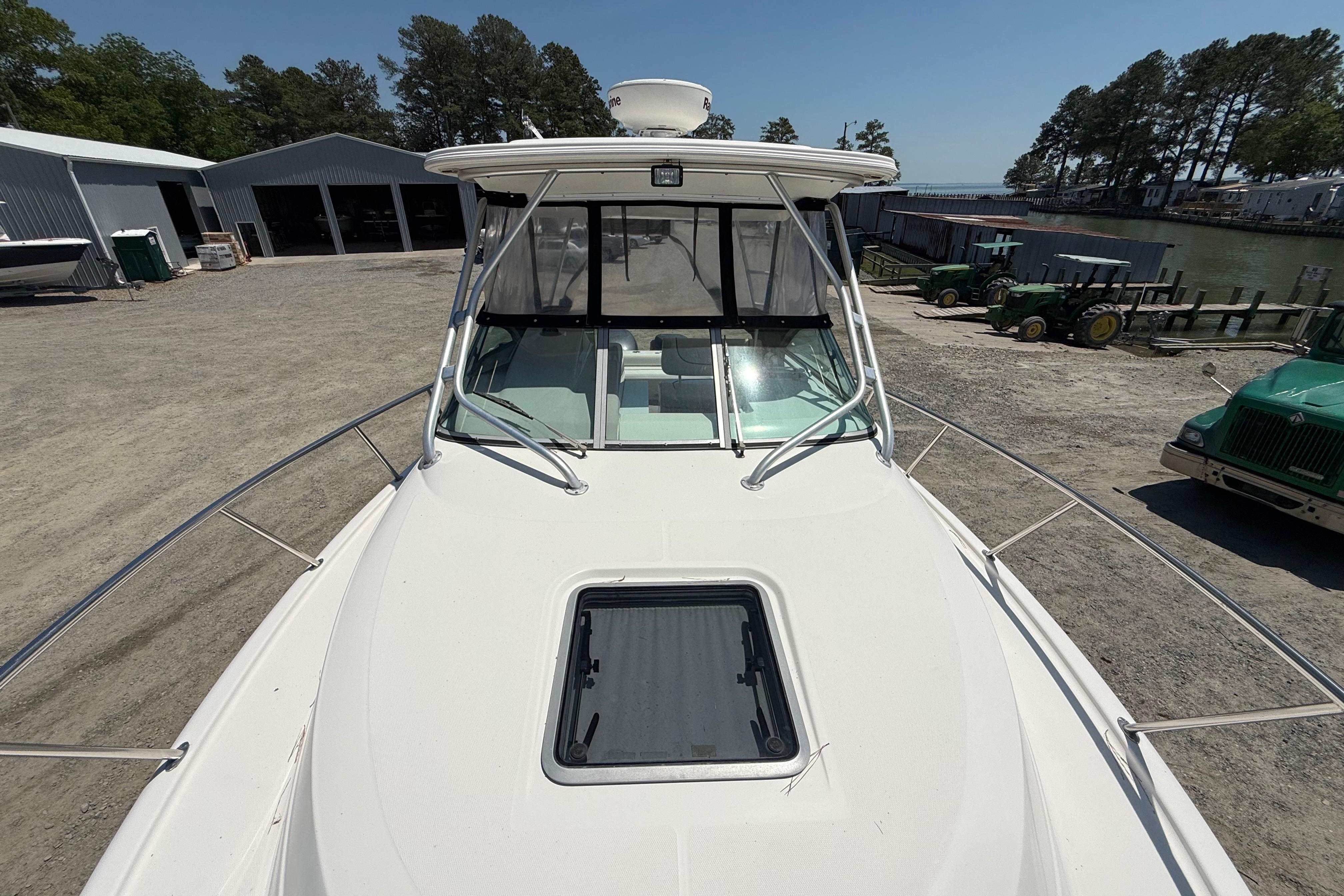 2007 Robalo R305 Walkaround boat docked, showcasing spacious deck and windshield.