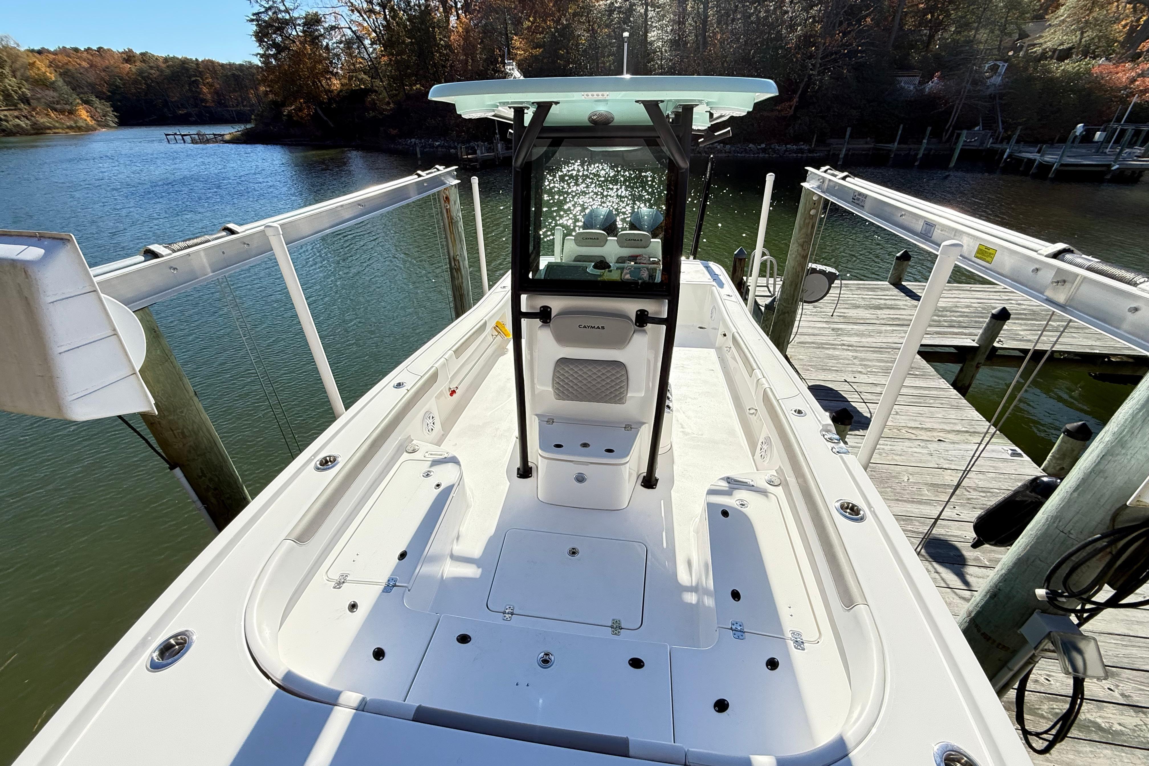 2023 Caymas 281 HB boat docked on a scenic lake with autumn foliage.