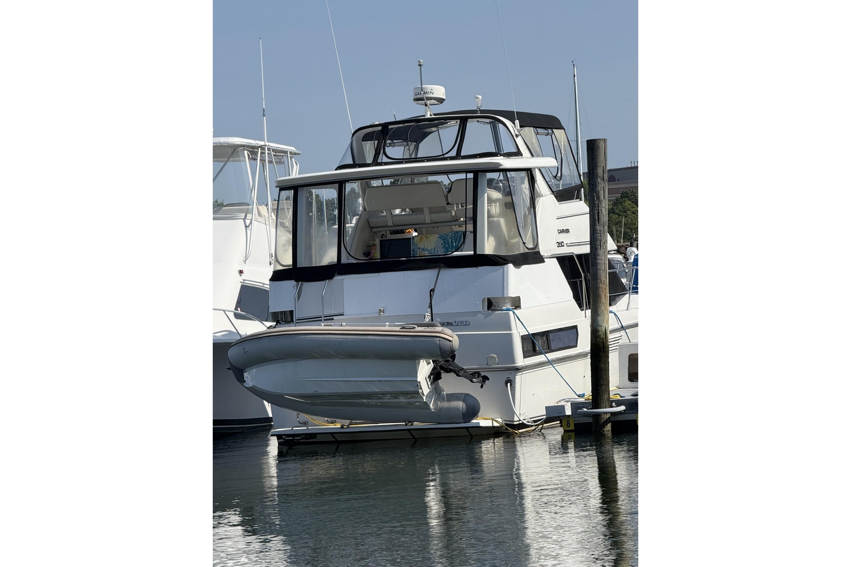 1993 Carver 350 Motor Yacht docked at marina, rear view with inflatable boat attached.