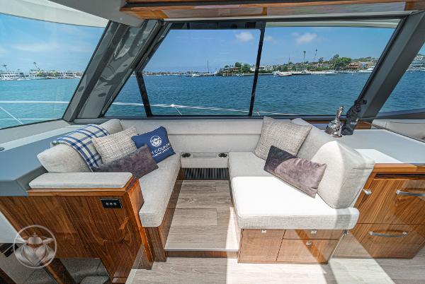Luxurious interior of 2025 Riviera 645 SUV yacht with waterfront view.