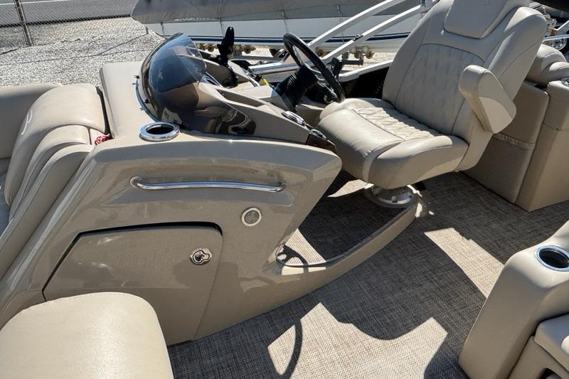 2014 Bennington 2575 RCW boat interior with beige seating and steering console.